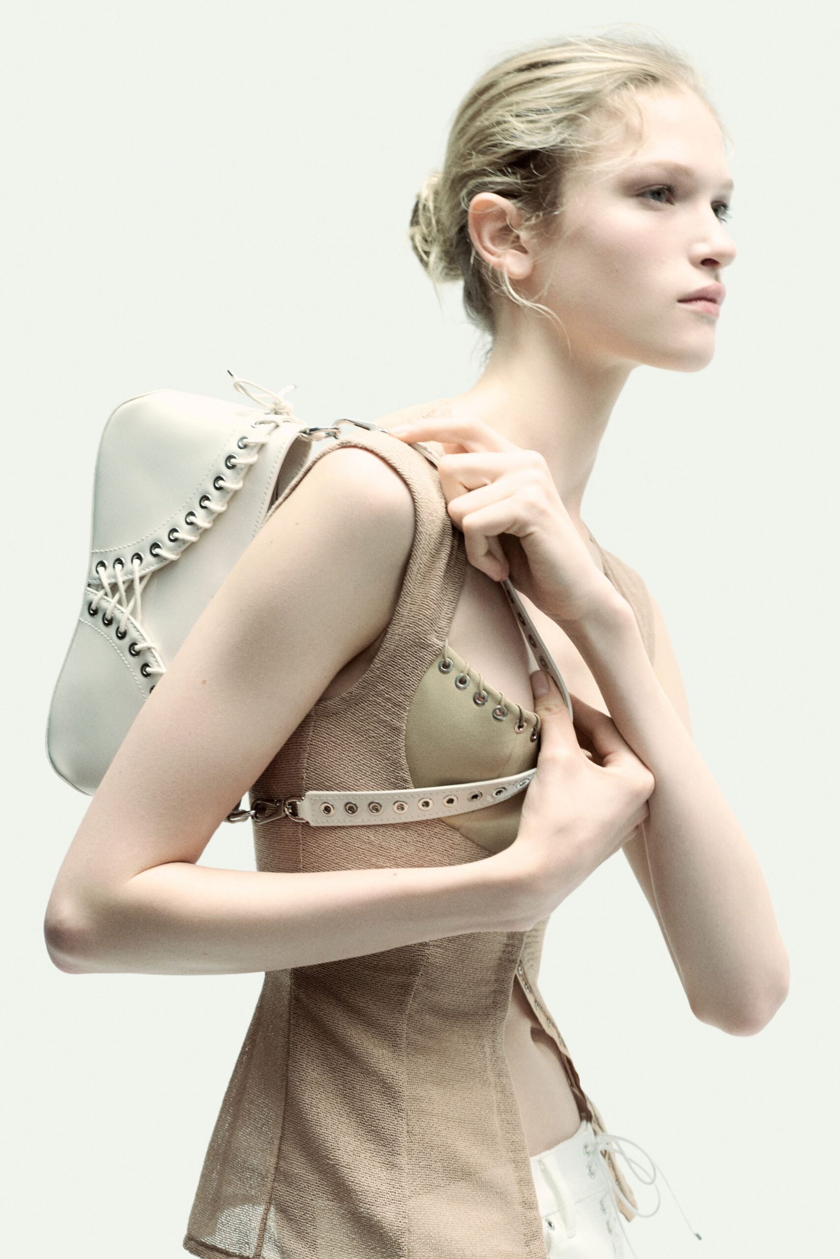 beige fitted sleeveless top with white bag