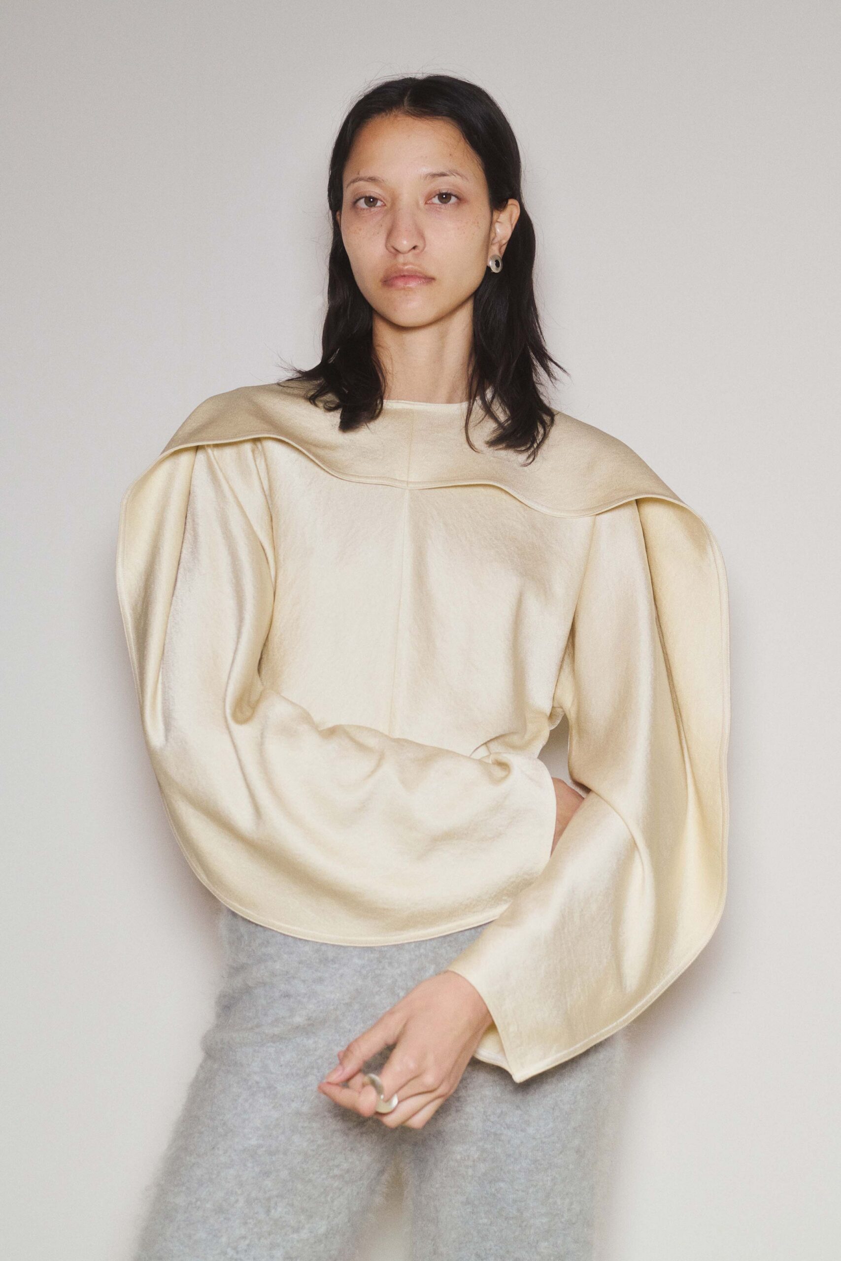 beige silk draped top and gray wool pants
