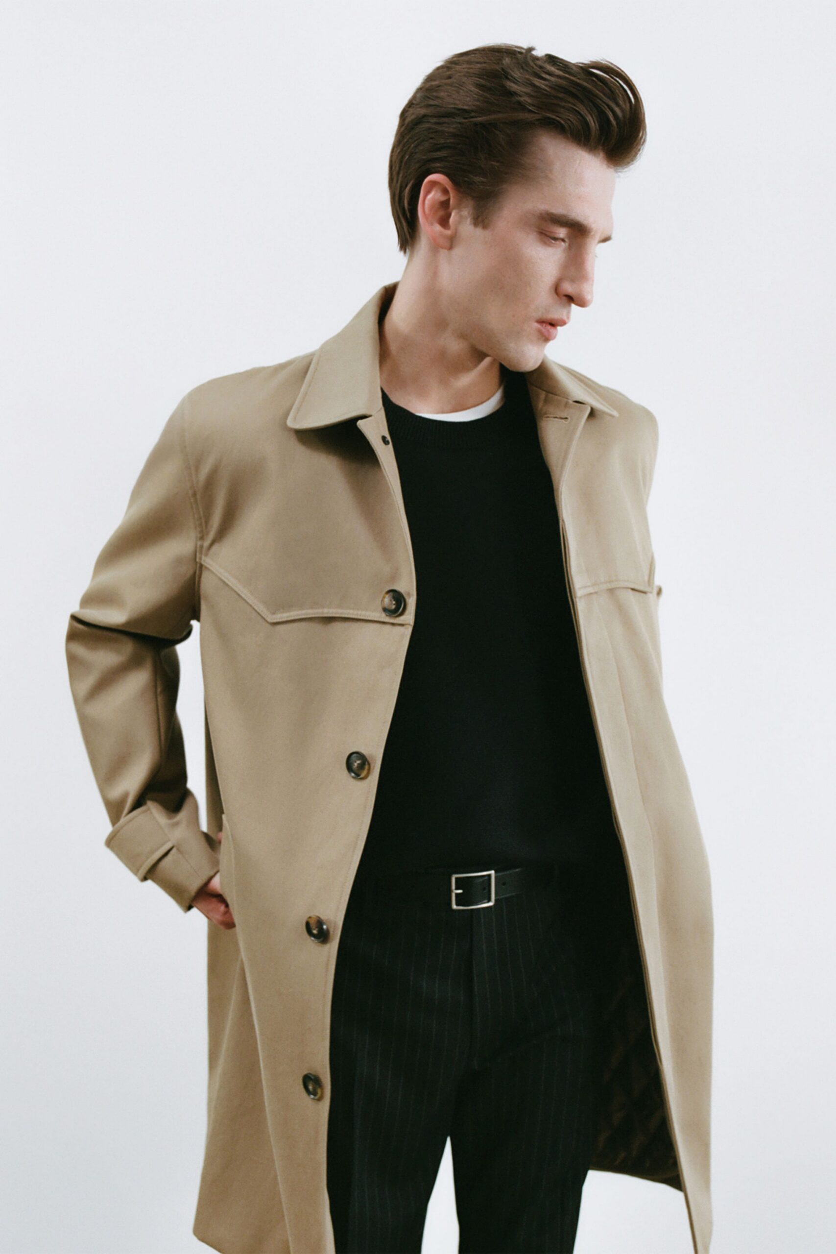 beige coat black sweater striped pants