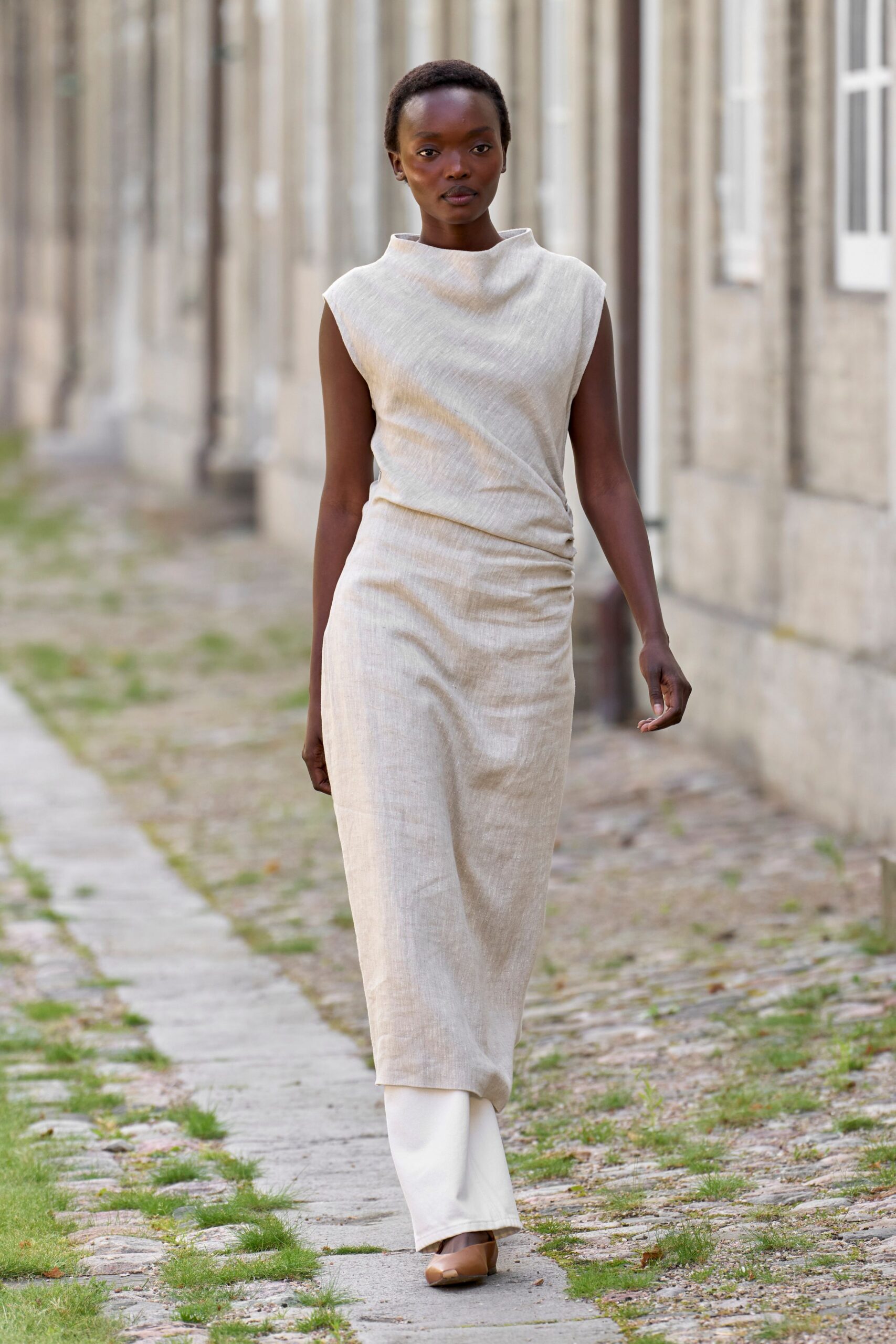 beige fitted sleeveless dress with white pants