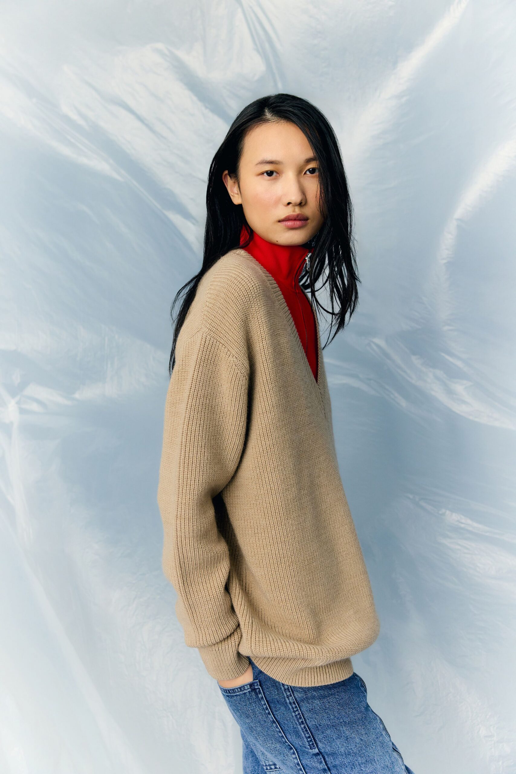 beige sweater red top blue jeans