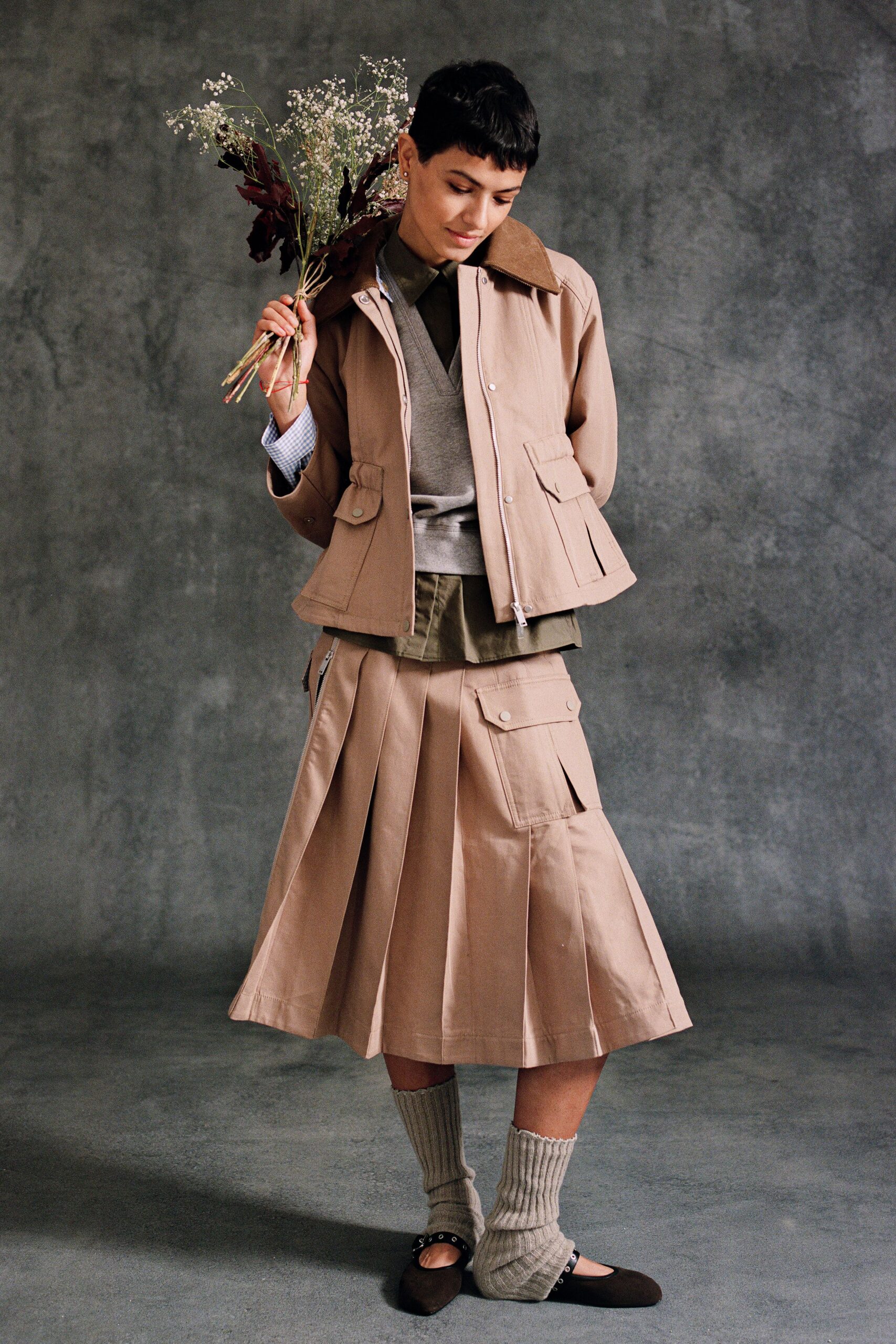 beige jacket gray top pleated skirt