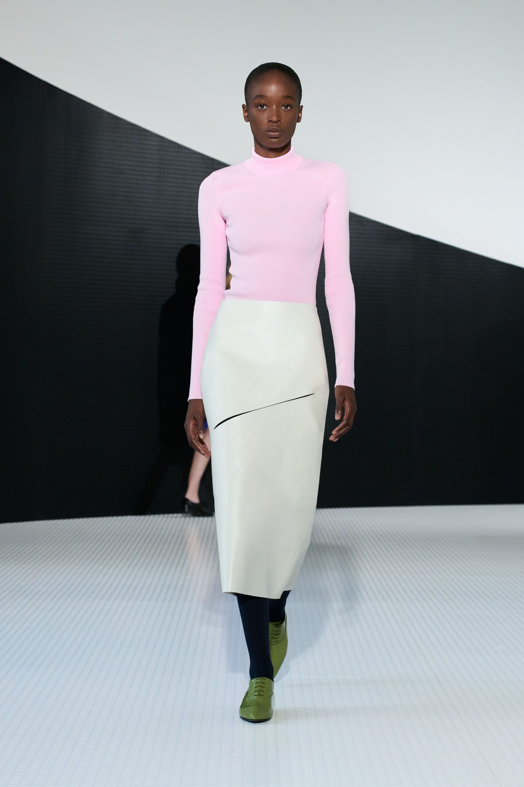 pink fitted top white asymmetric skirt green shoes