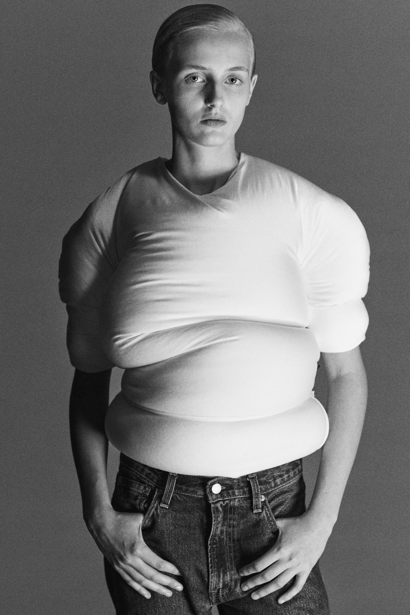 white fitted top with padded sleeves and blue jeans