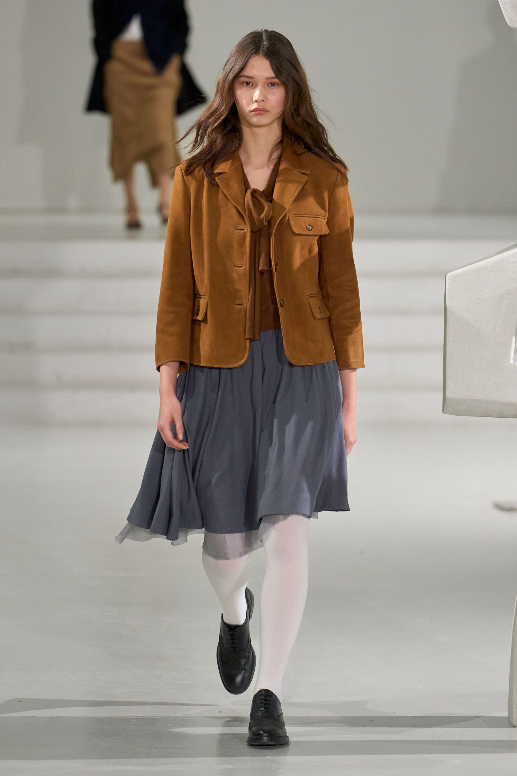 brown suede jacket with gray pleated skirt
