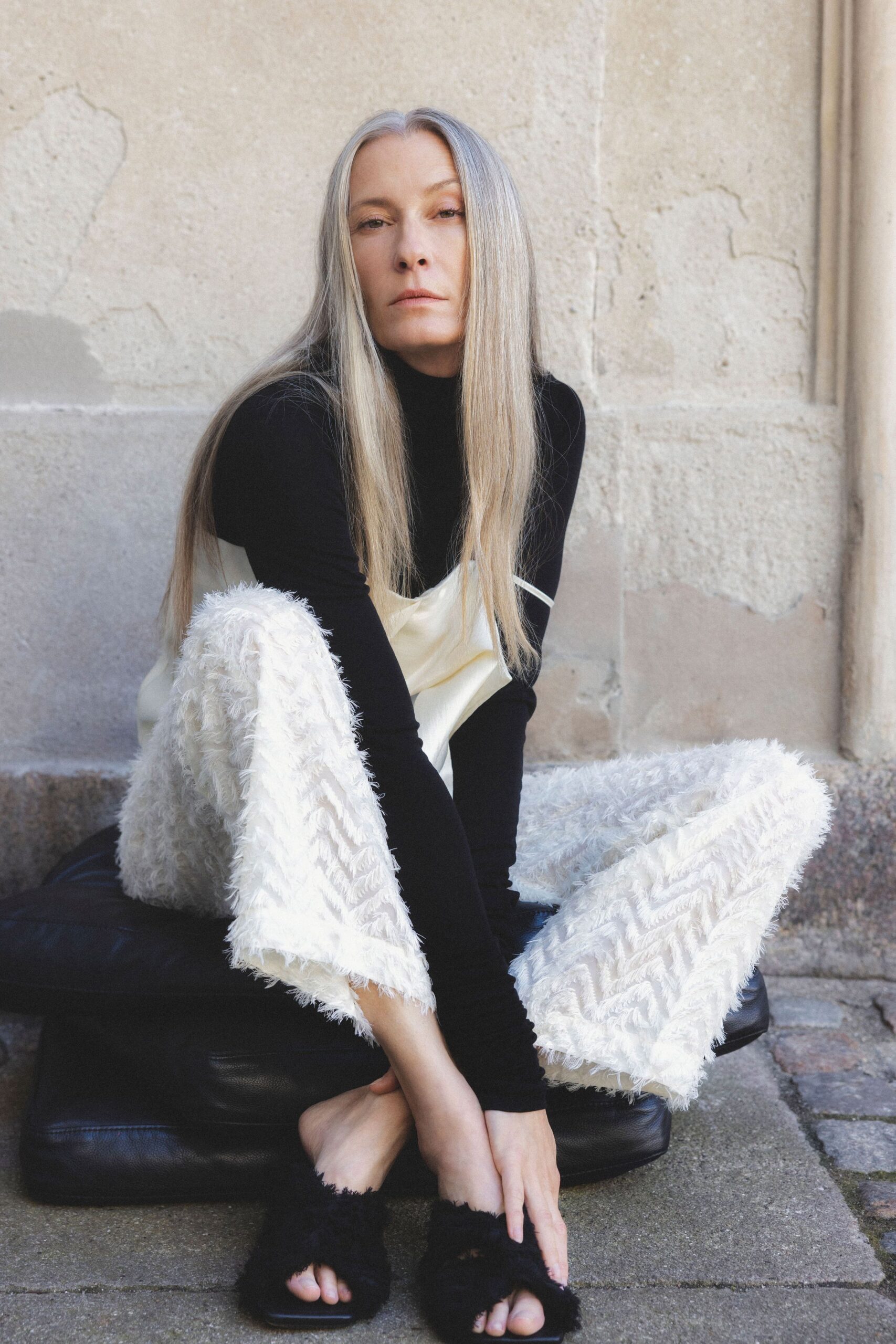black fitted turtleneck top with white zigzag pants