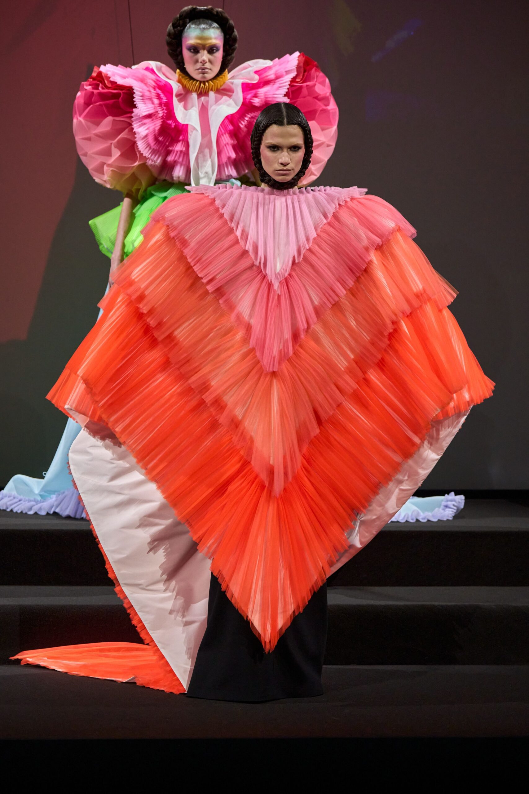pink and orange pleated cape with black dress