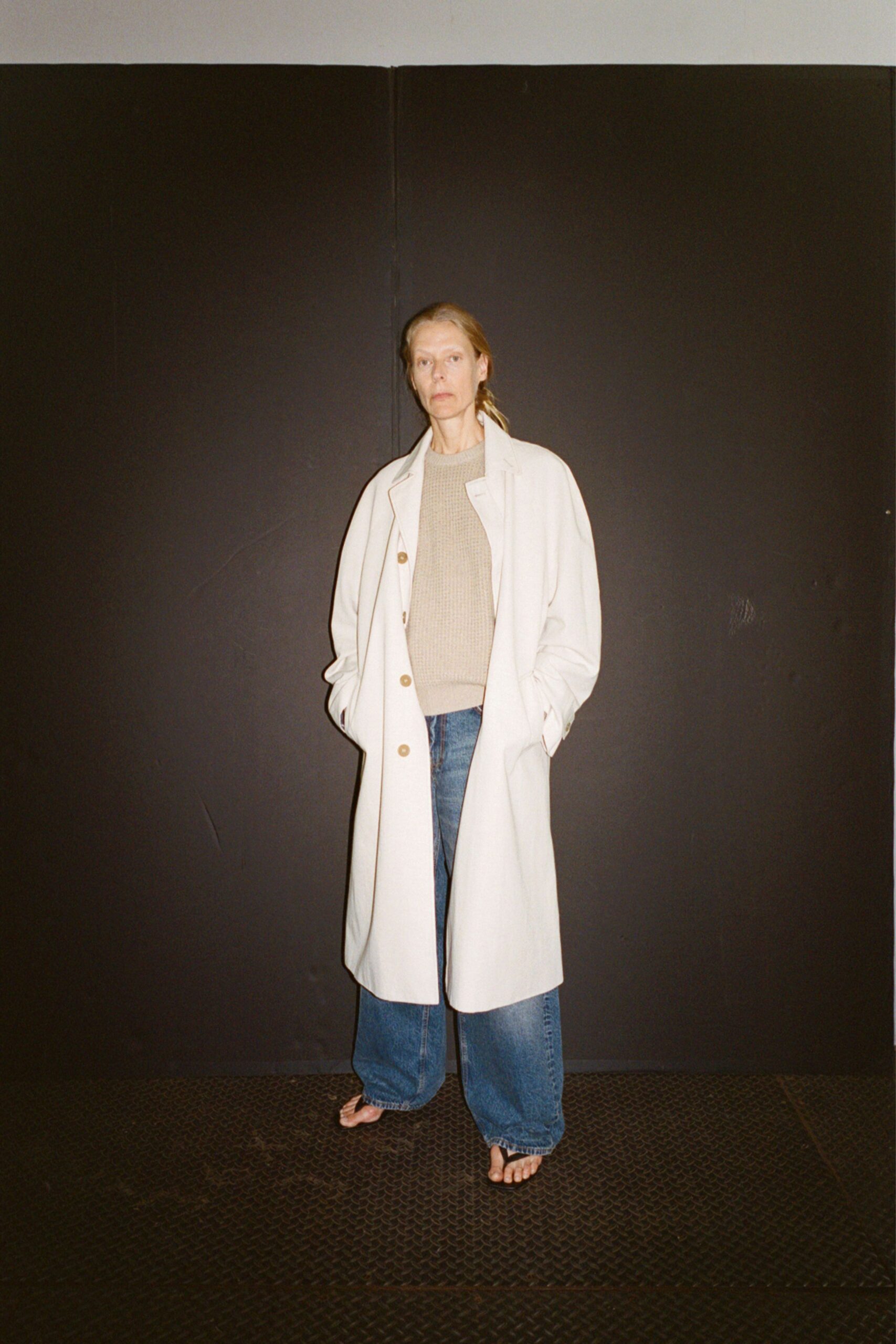 white coat beige sweater blue jeans black sandals