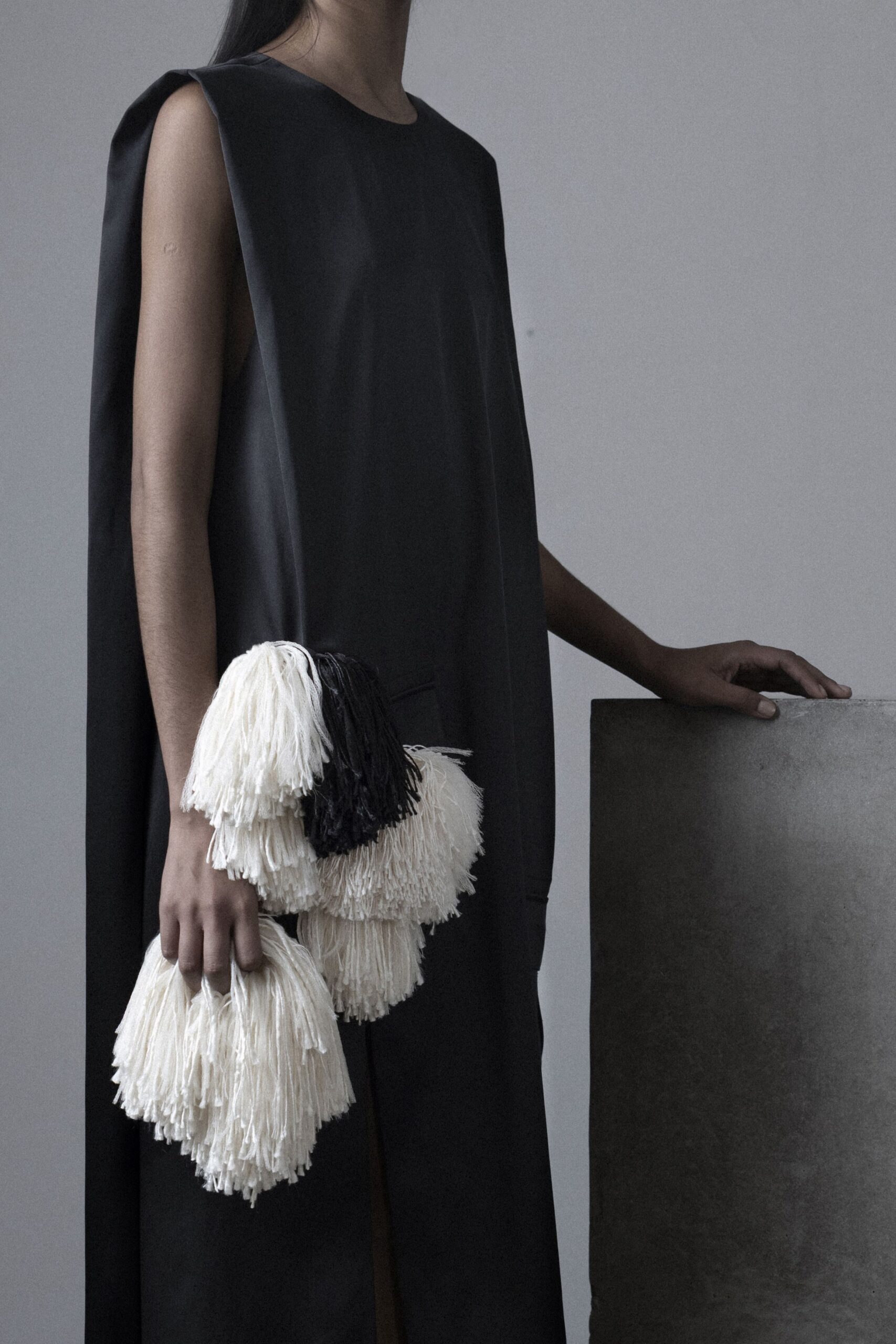 black relaxed sleeveless dress with fringed bag