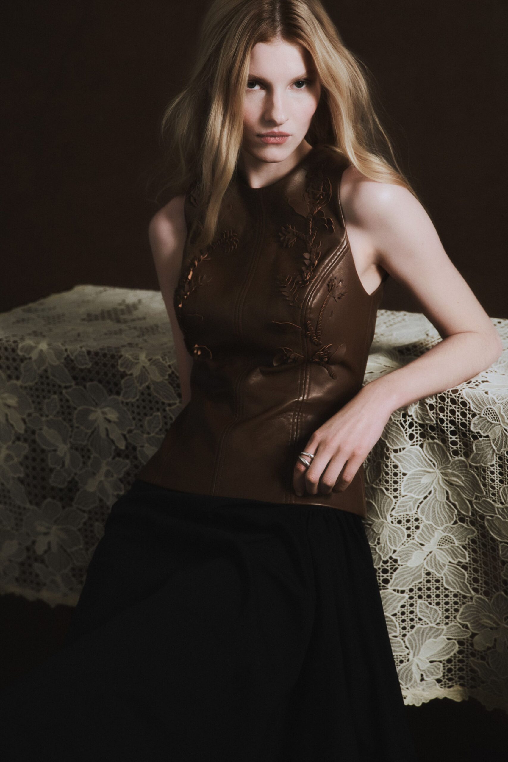 brown leather sleeveless top and black skirt