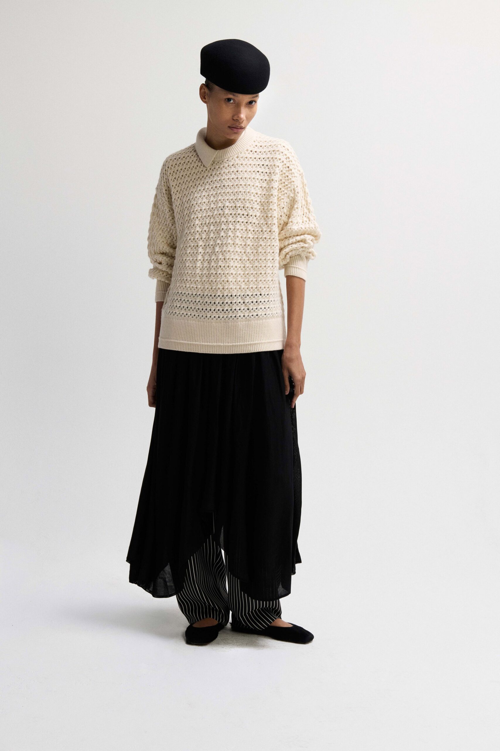 beige relaxed sweater with black skirt