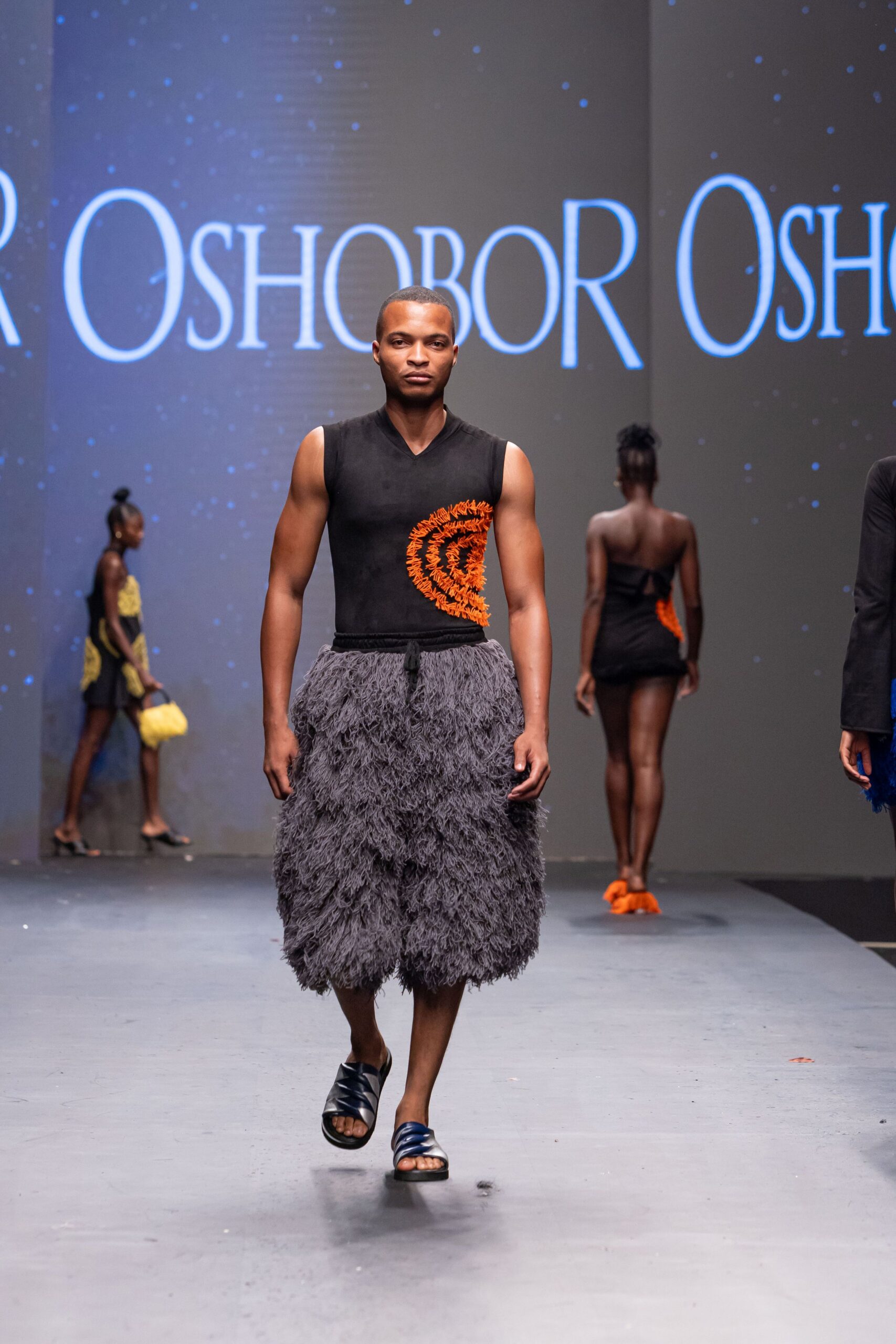 black fitted top with gray fringed pants