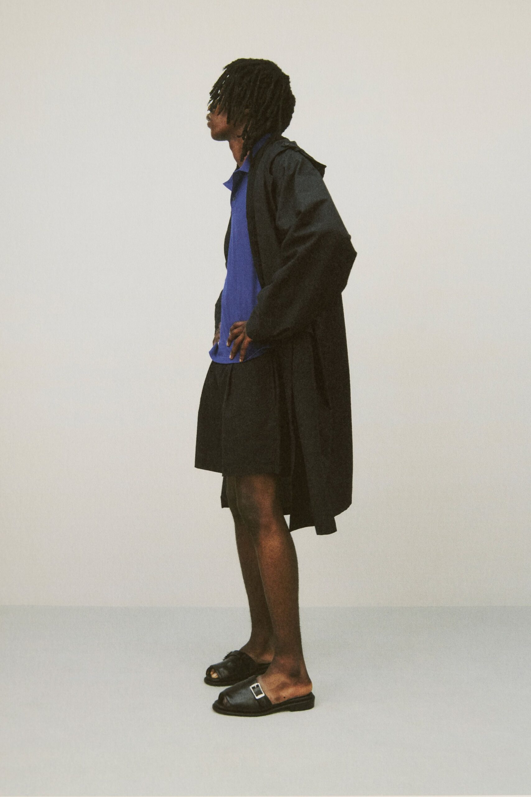 black coat blue shirt black shorts sandals