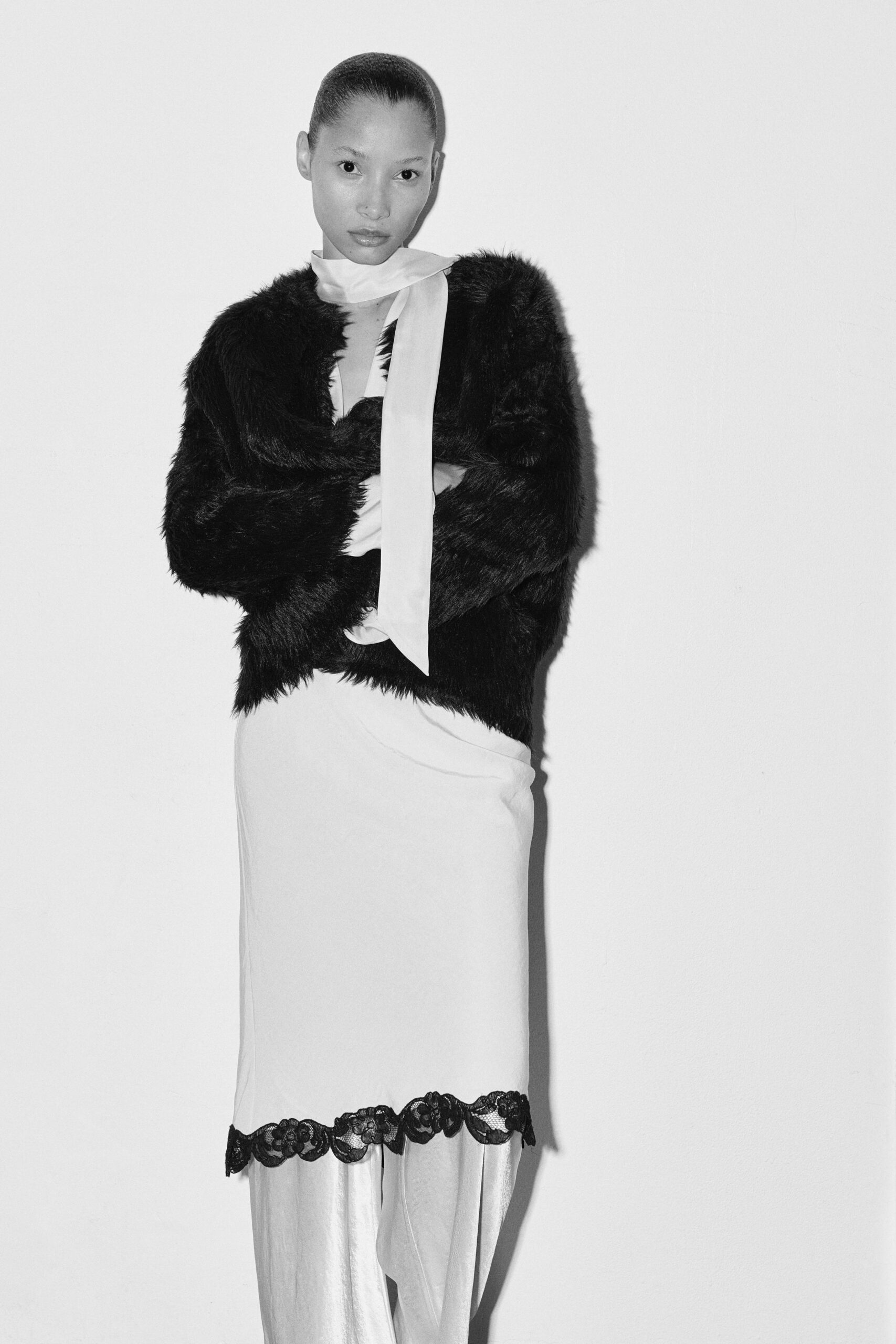black faux-fur coat and white silk dress