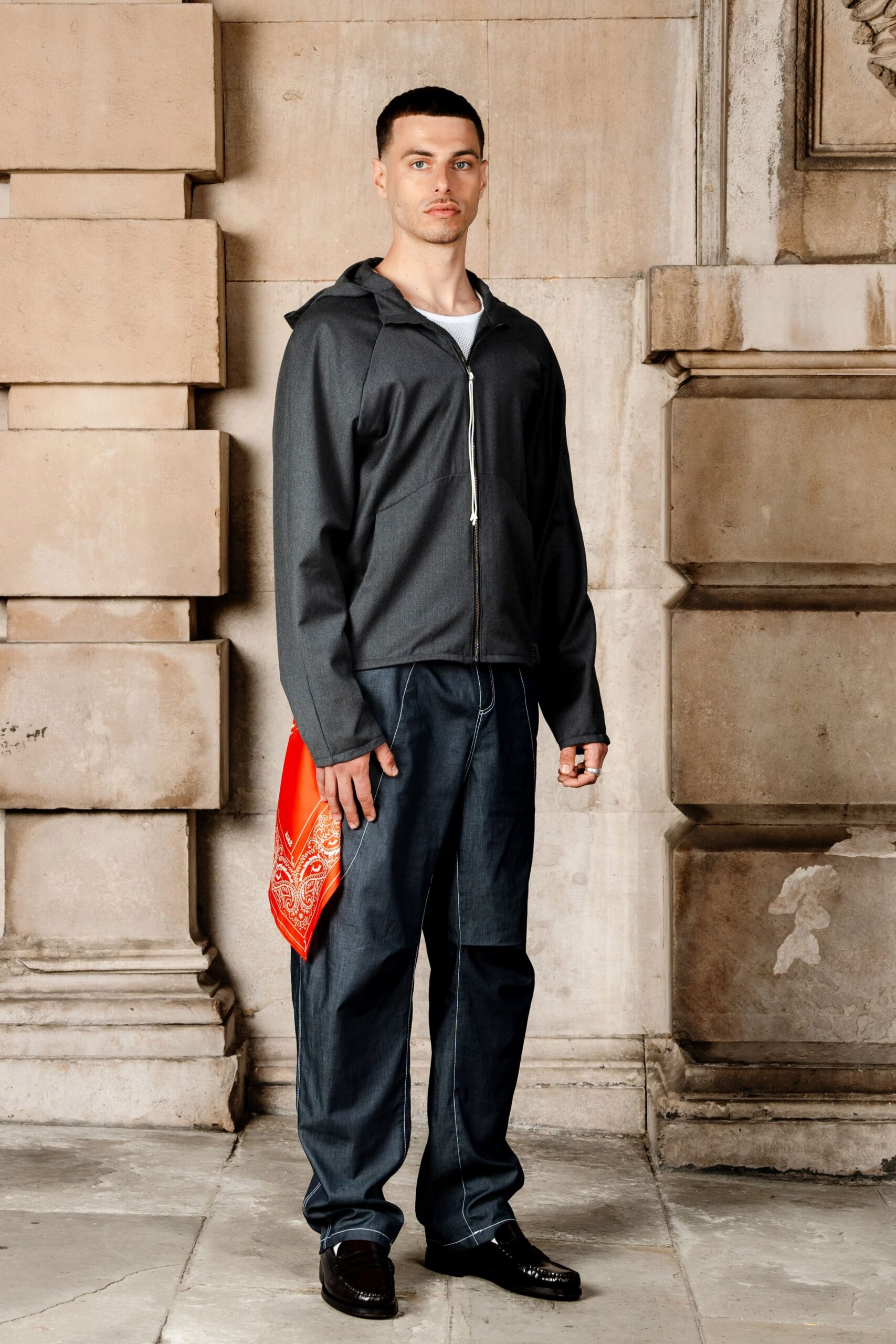 gray jacket blue pants black shoes red bag