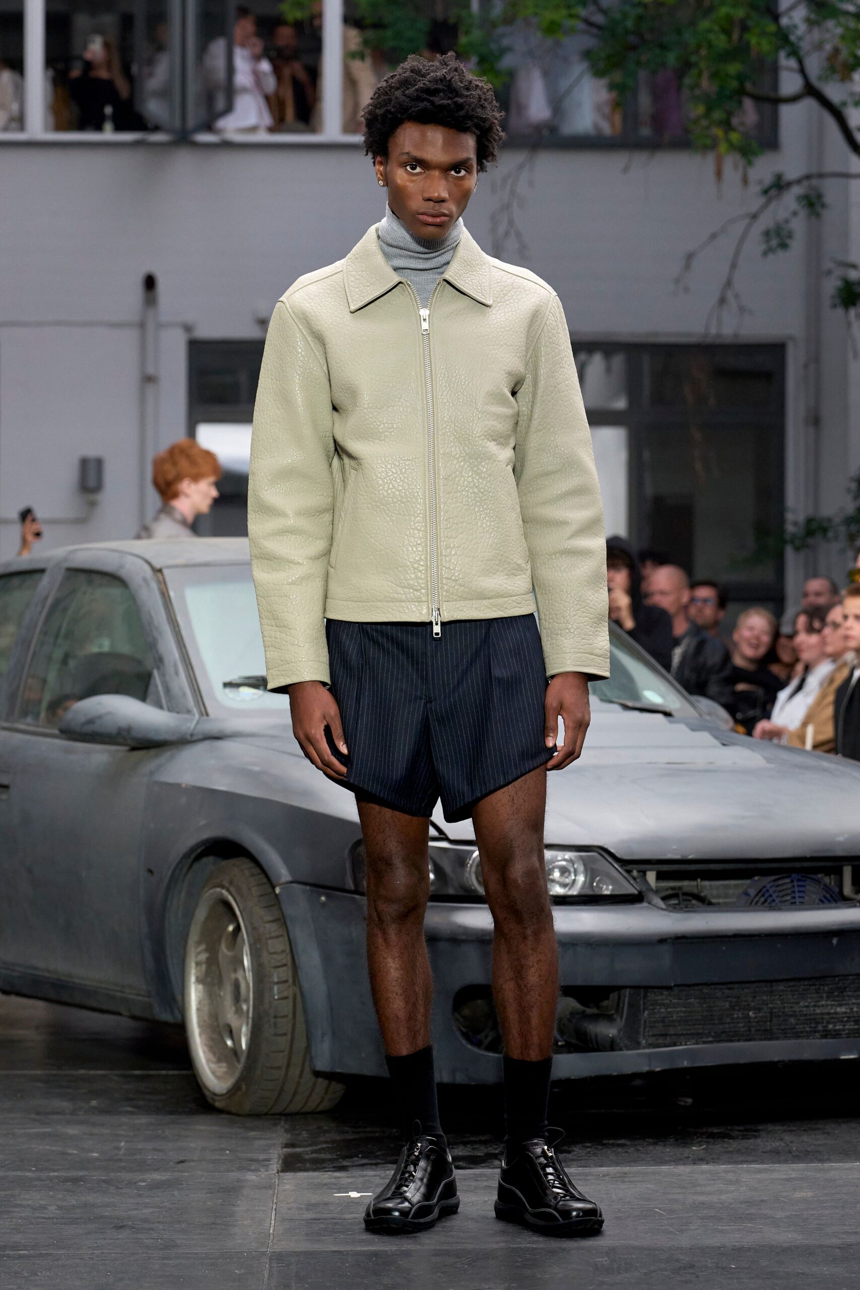 beige leather jacket with black shorts