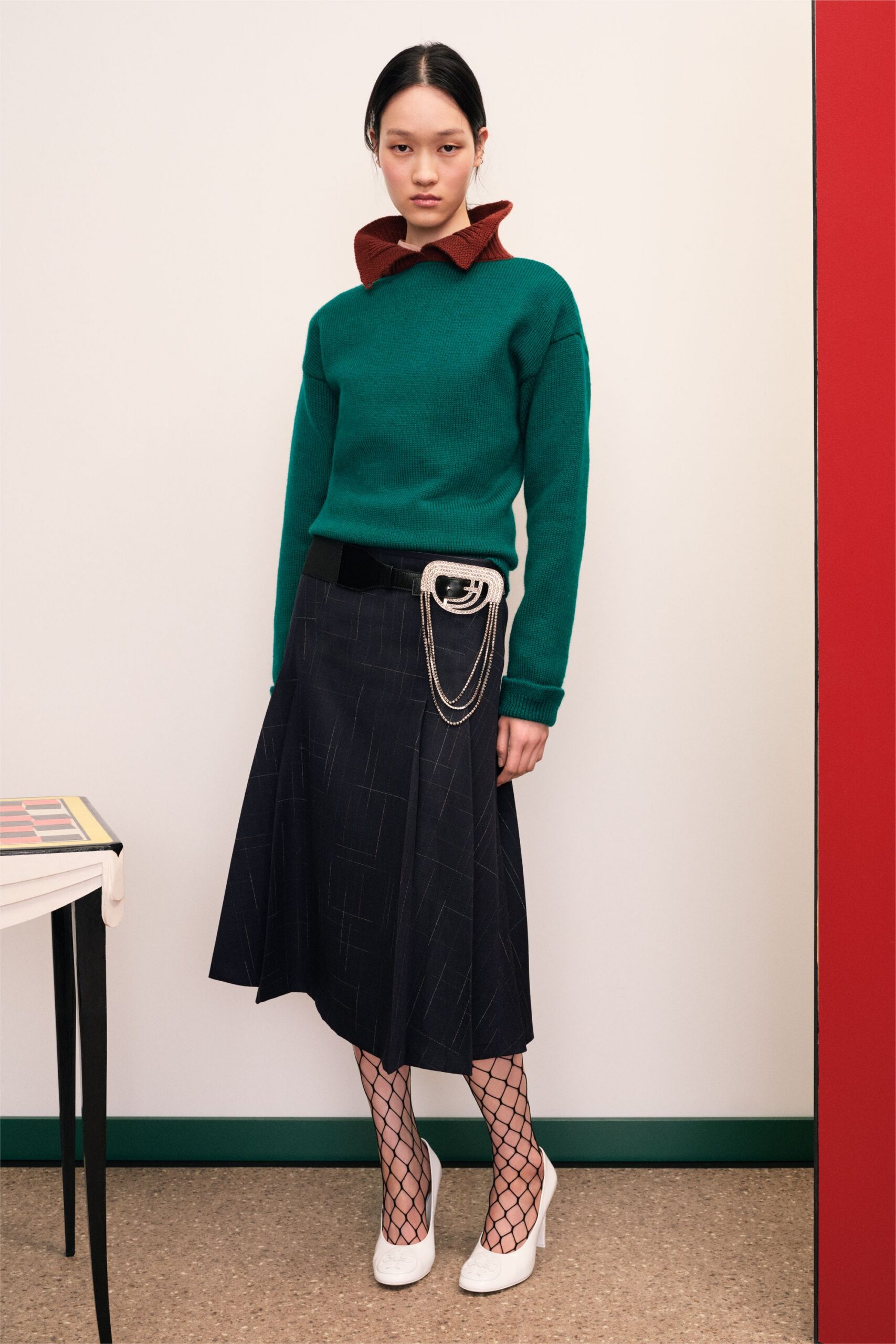 green wool relaxed sweater and black pleated skirt