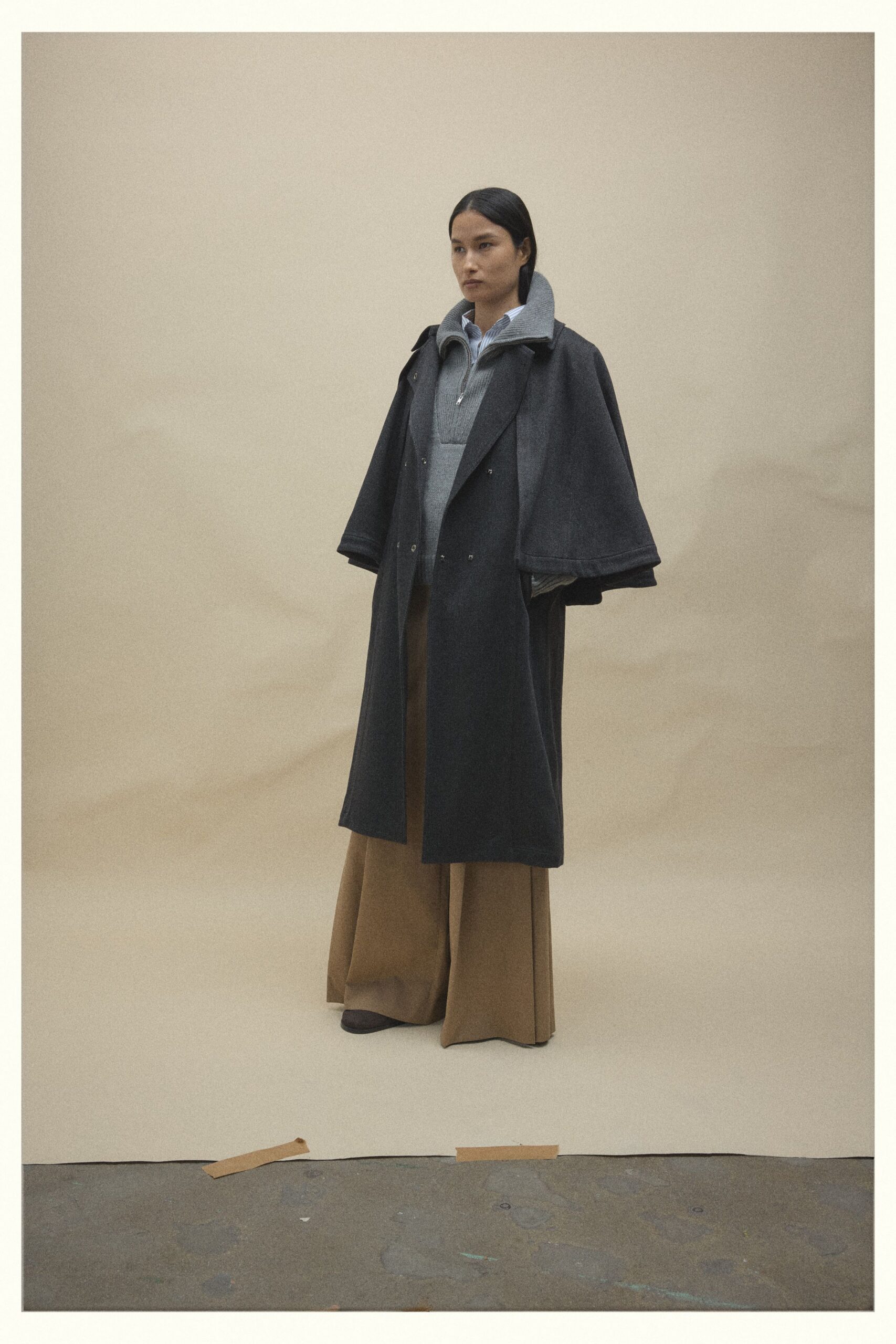 black coat gray sweater brown pants