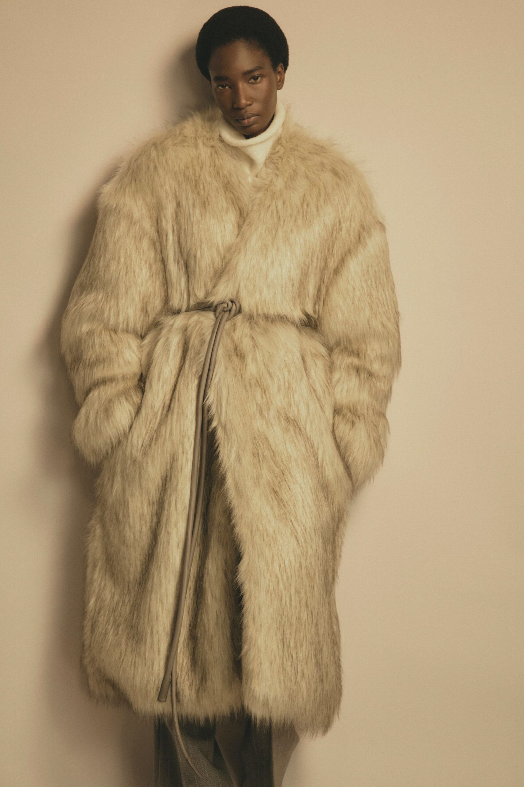 beige faux-fur coat with gray pants