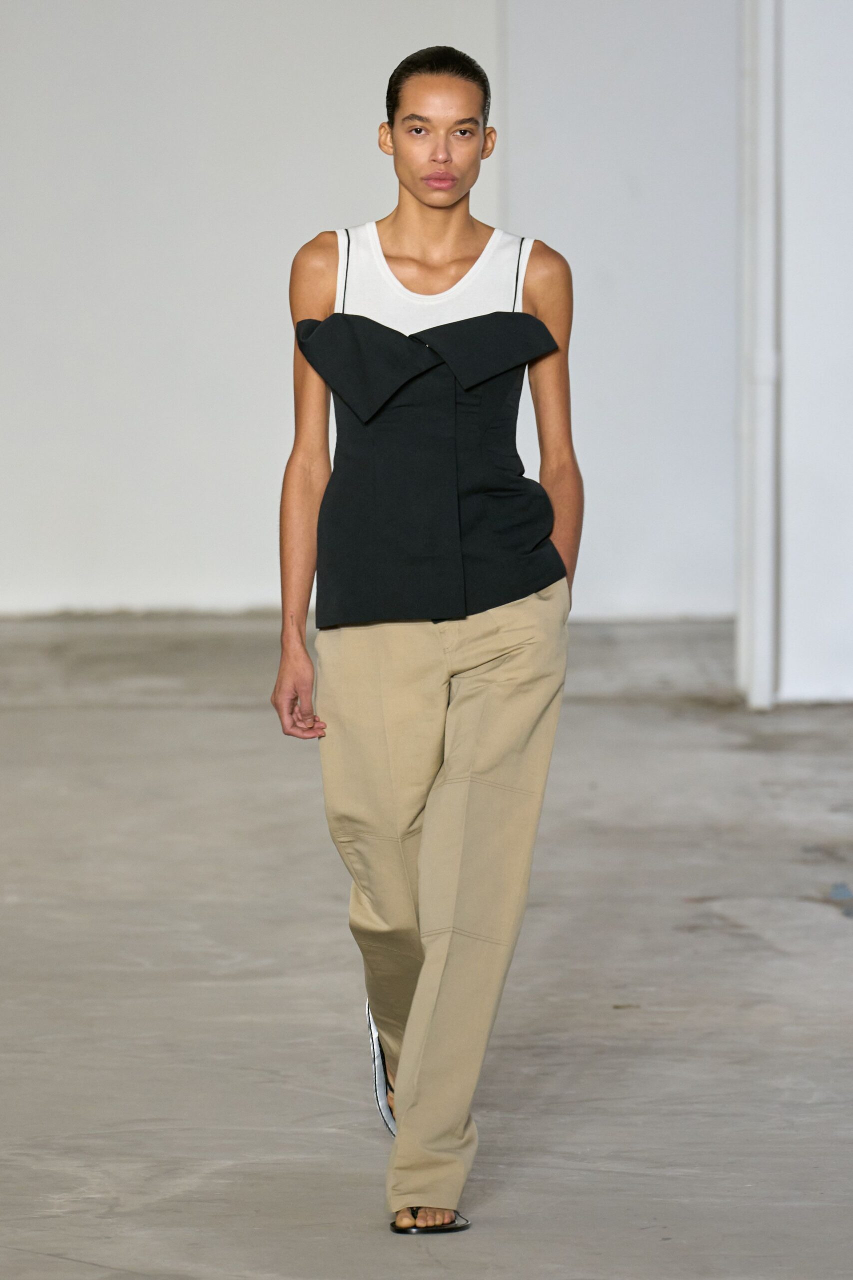 black and white fitted top with beige pants