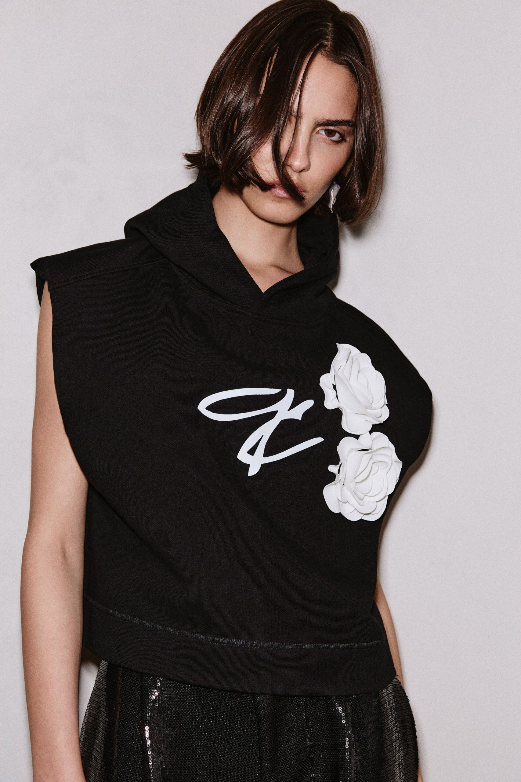 black sleeveless hoodie with pleated skirt