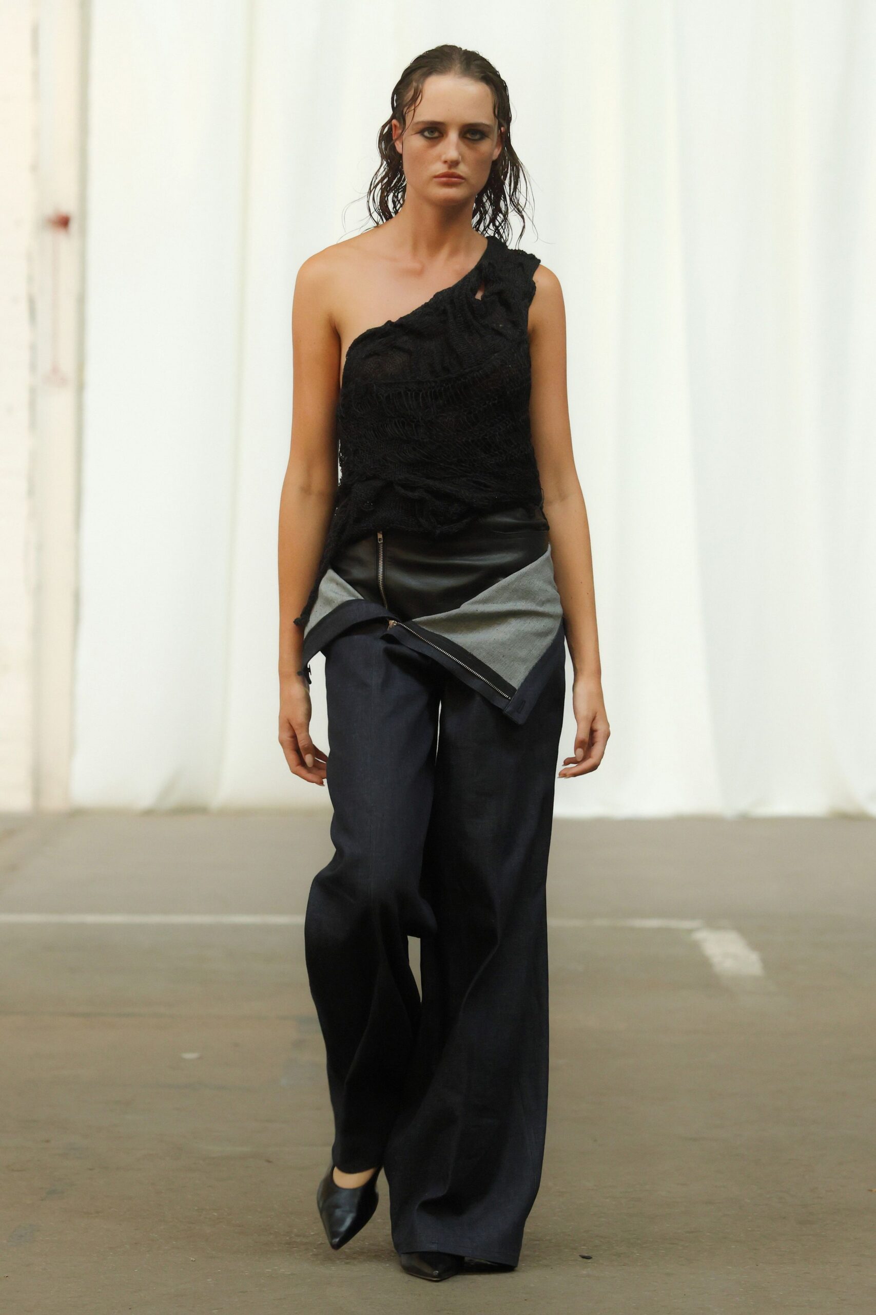 black lace asymmetric top with gray pants