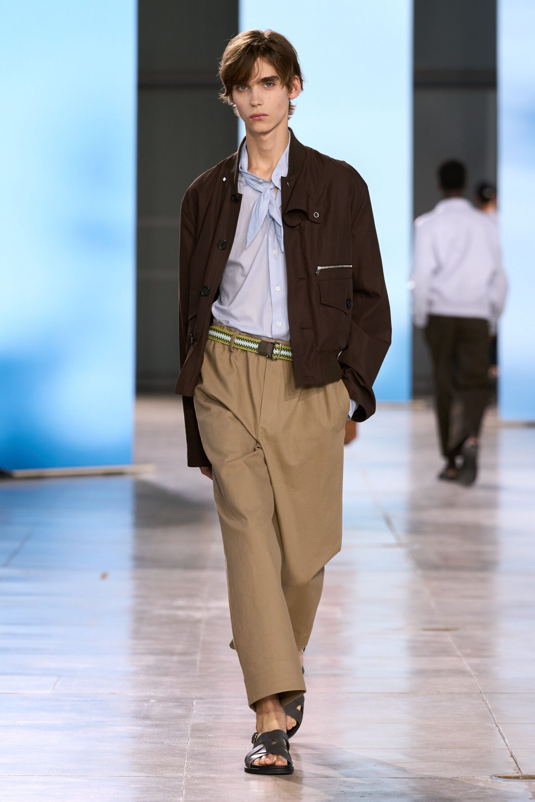 brown jacket blue shirt beige pants