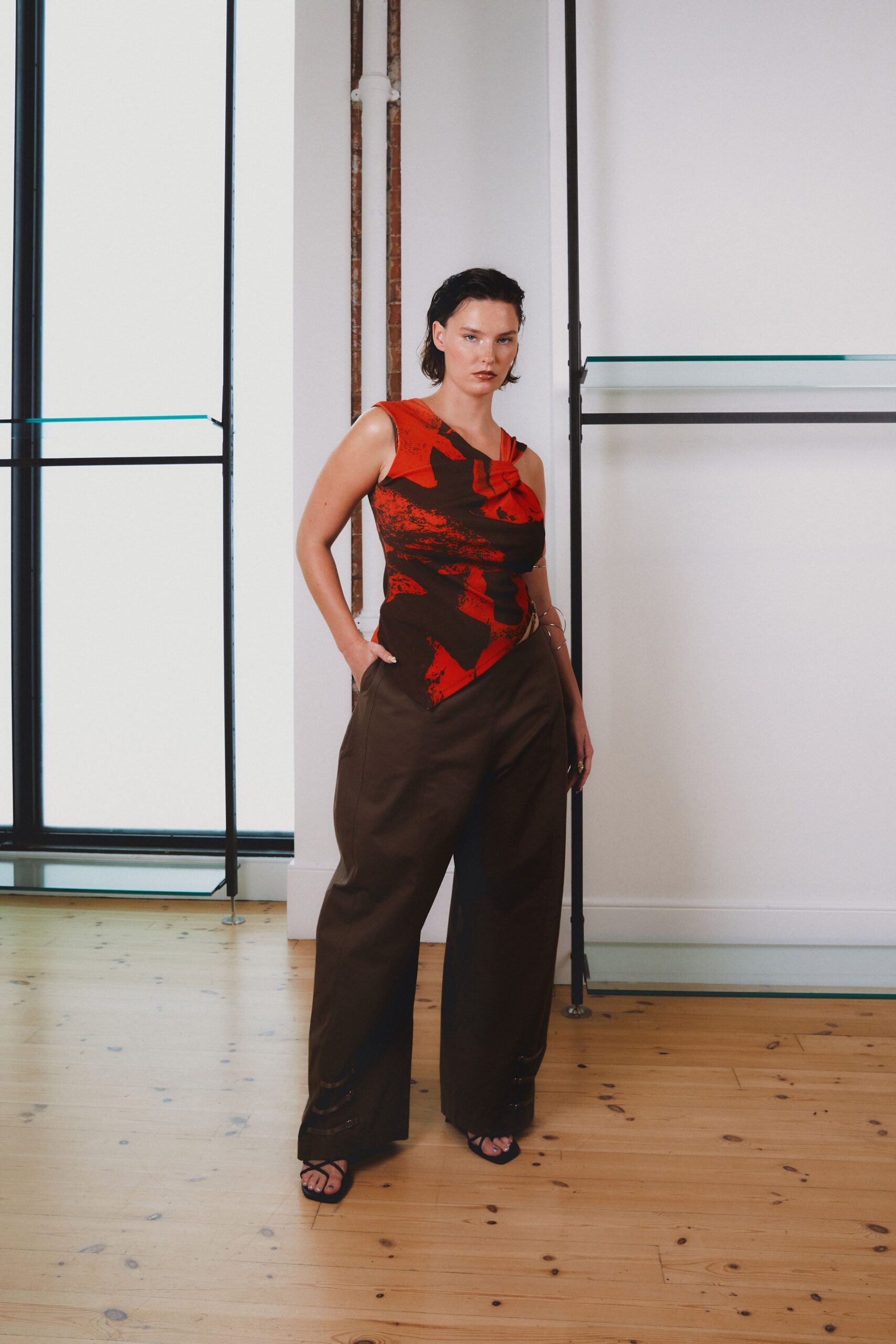 red printed sleeveless top with brown pants