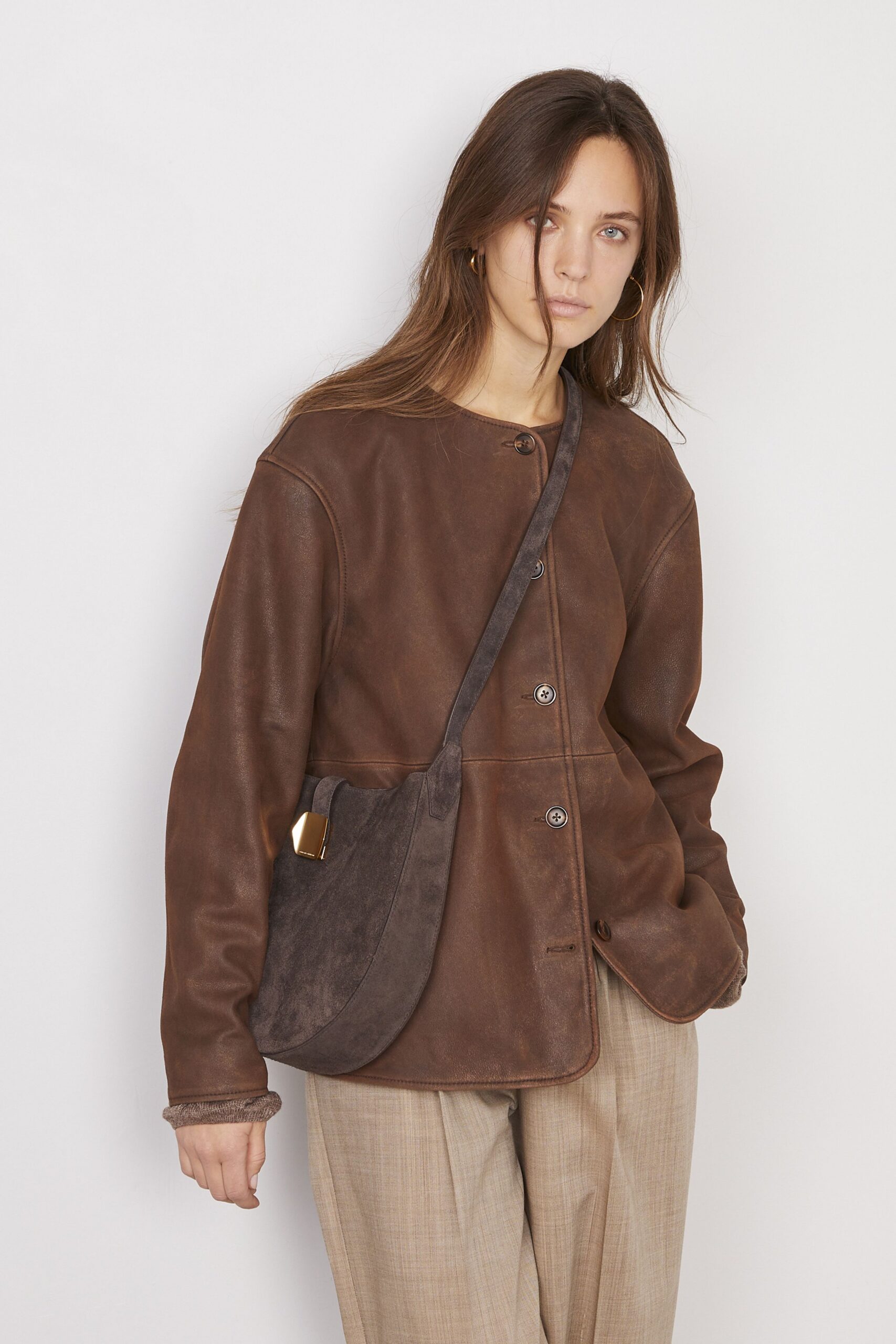 brown leather jacket with beige pants