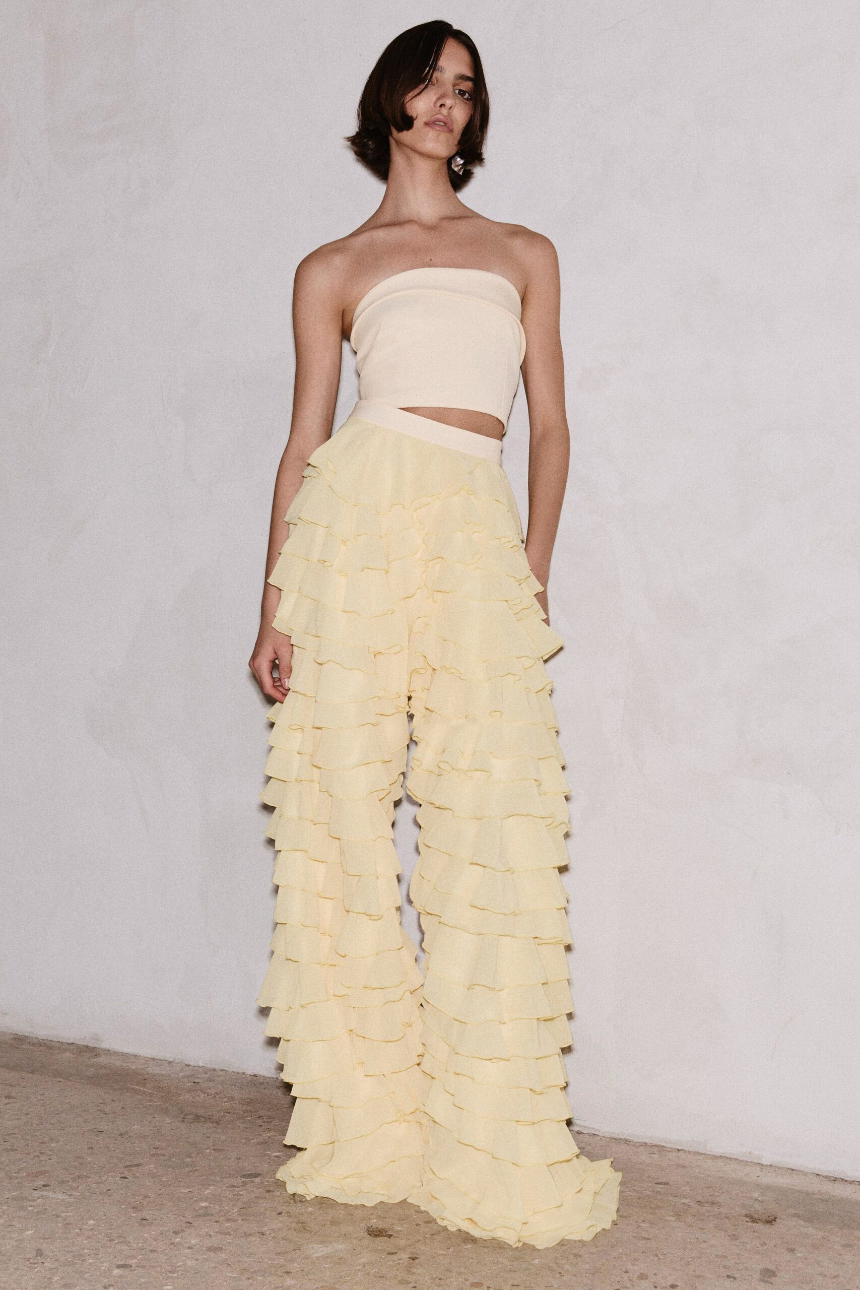 beige strapless top with yellow ruffled pants