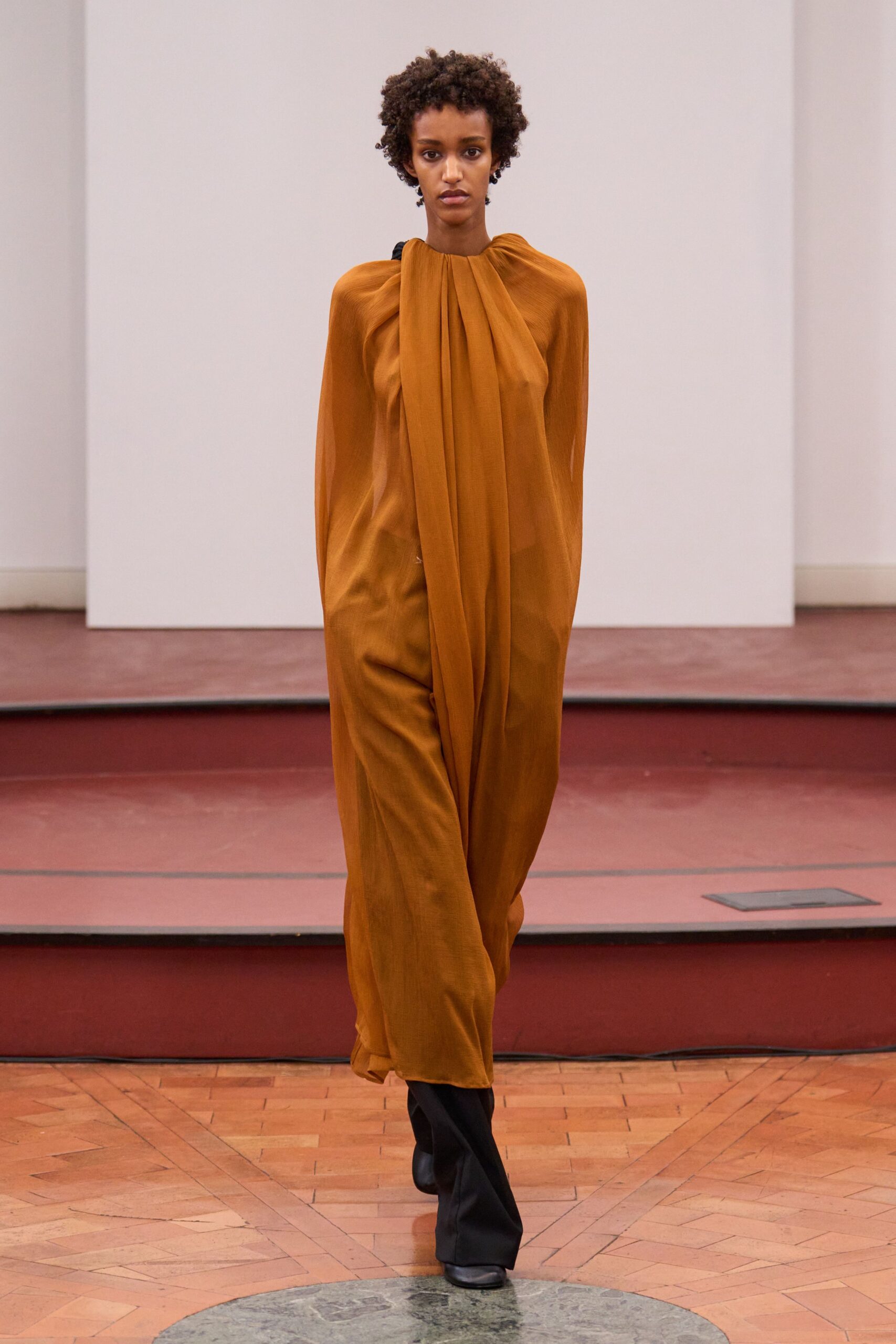 orange silk draped gown with black boots
