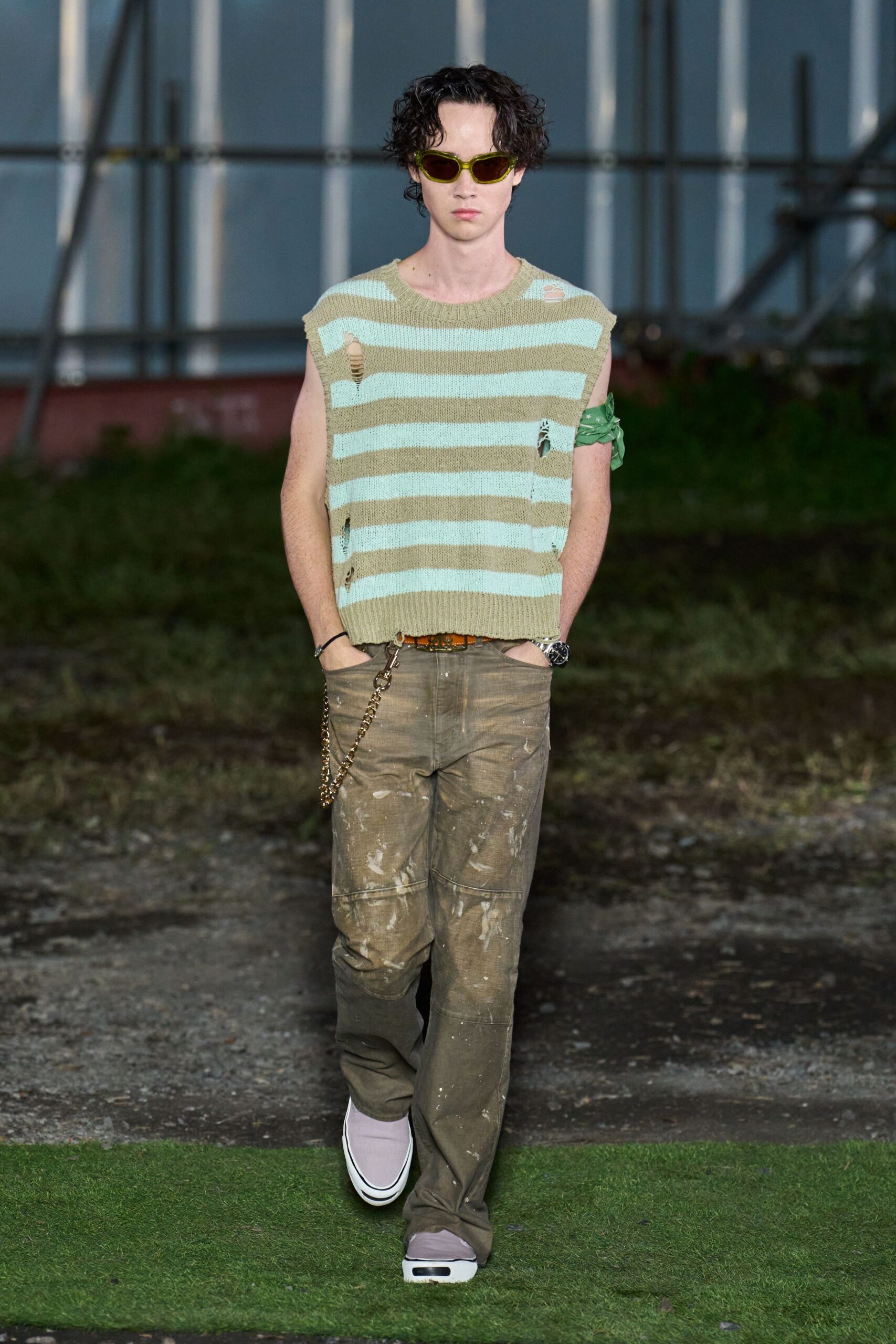 green striped sleeveless sweater with distressed pants