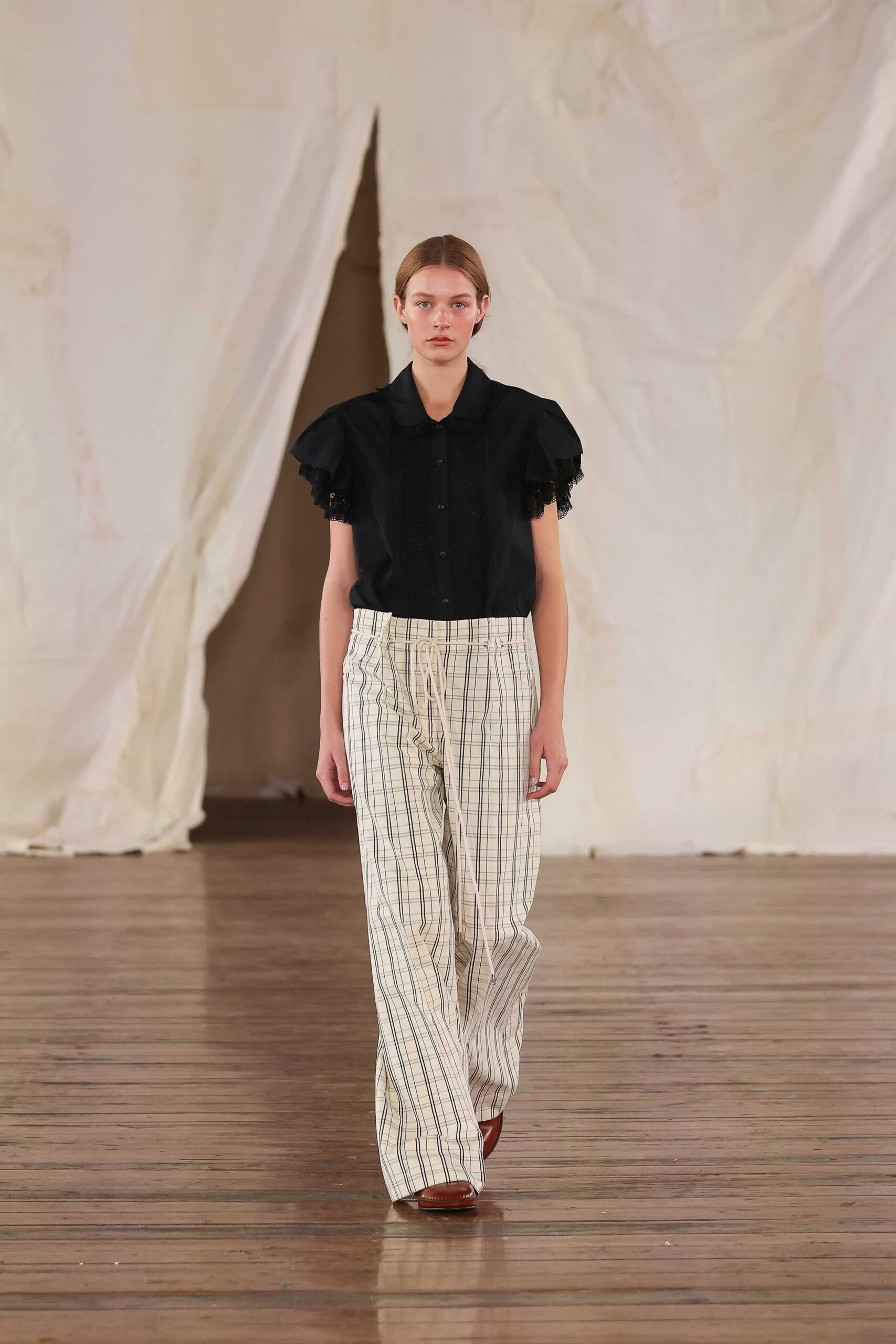 black shirt with ruffled sleeves and striped pants