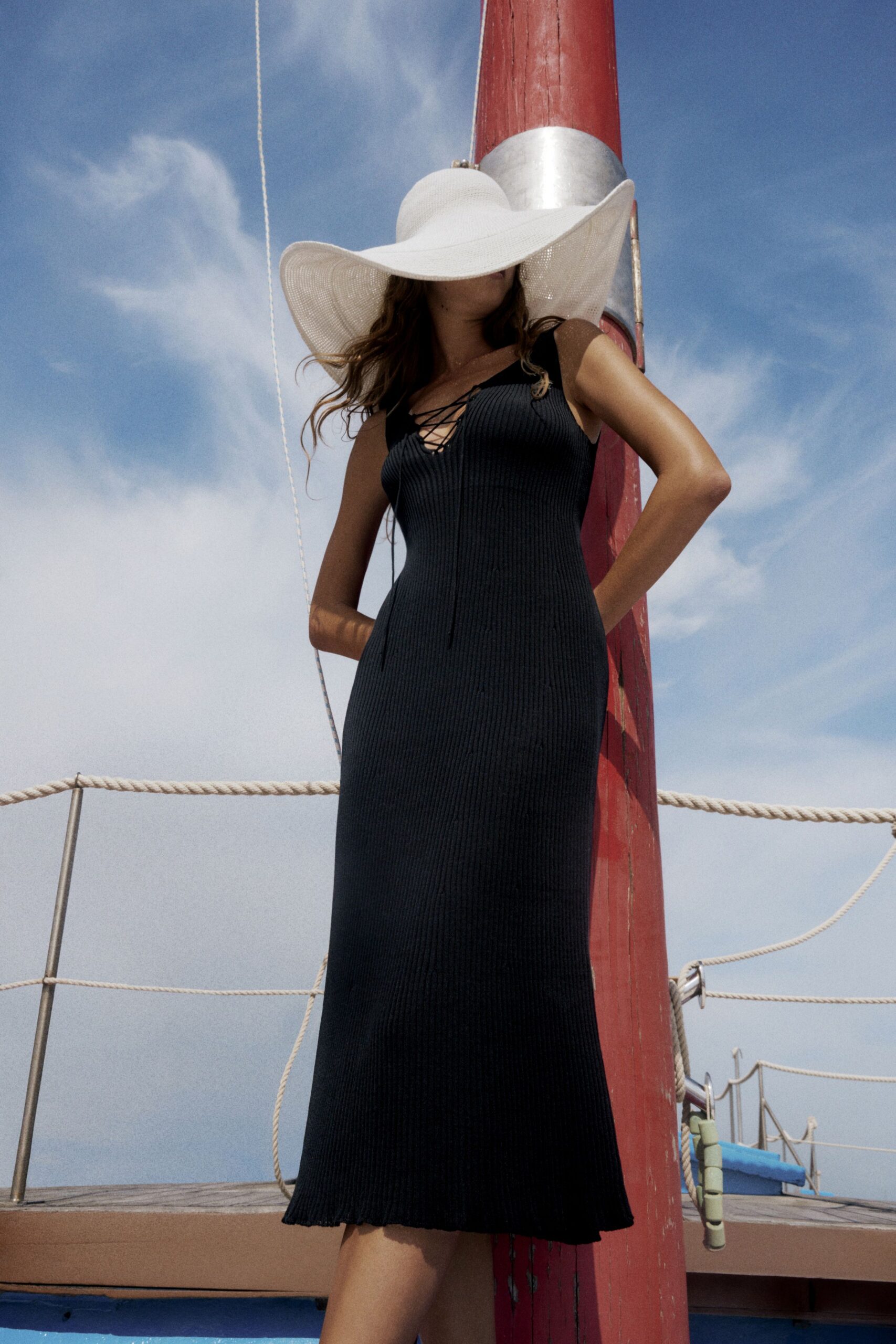 black fitted midi dress with white hat
