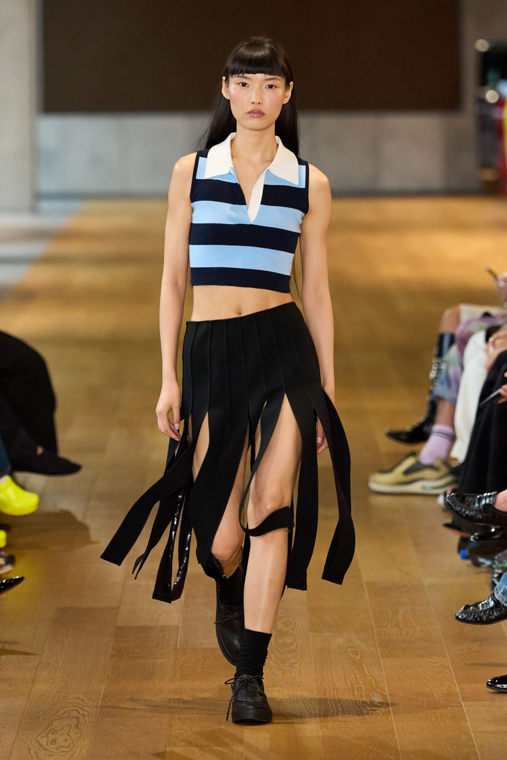 blue striped sleeveless top and black pleated skirt