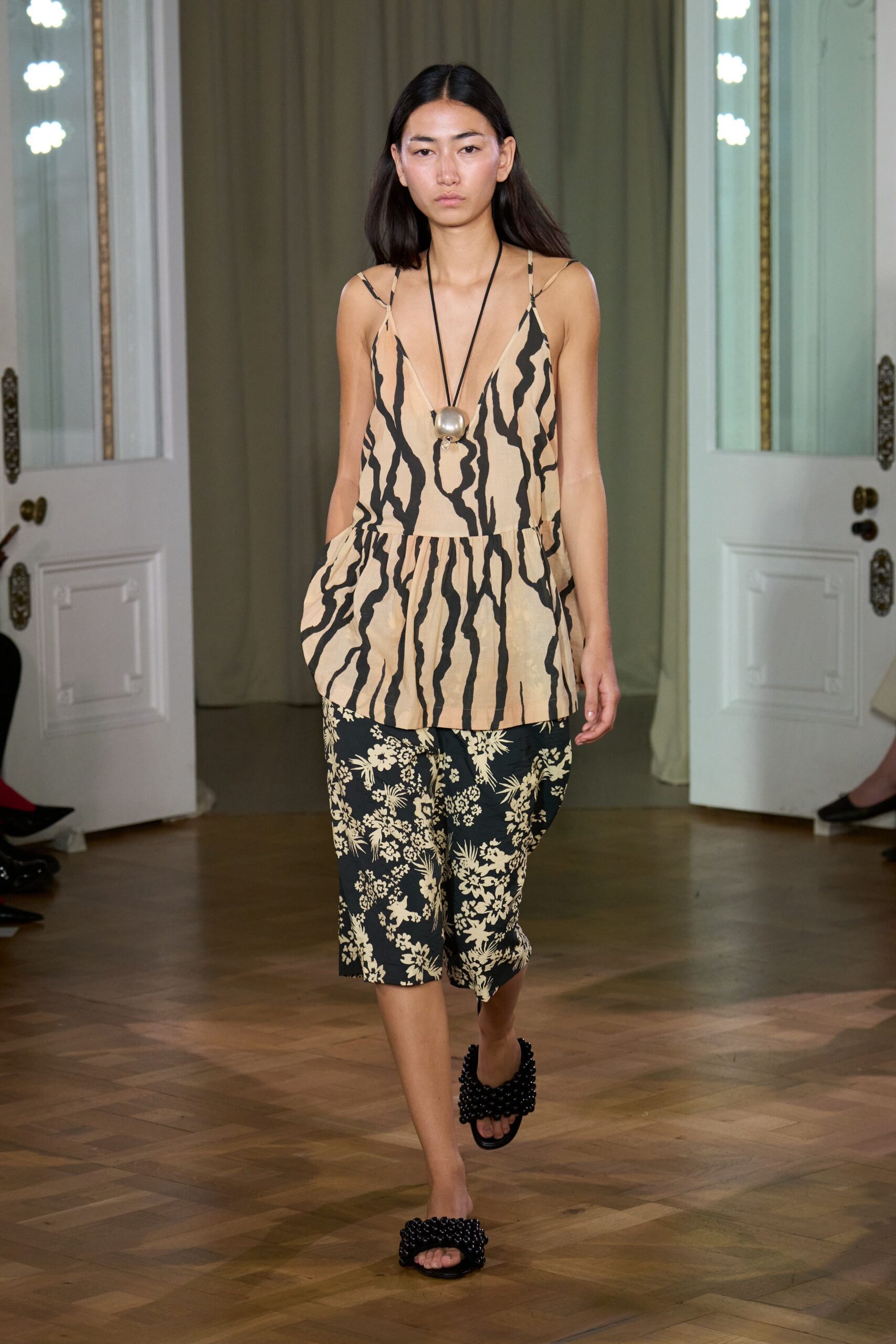 beige printed sleeveless top with black pants