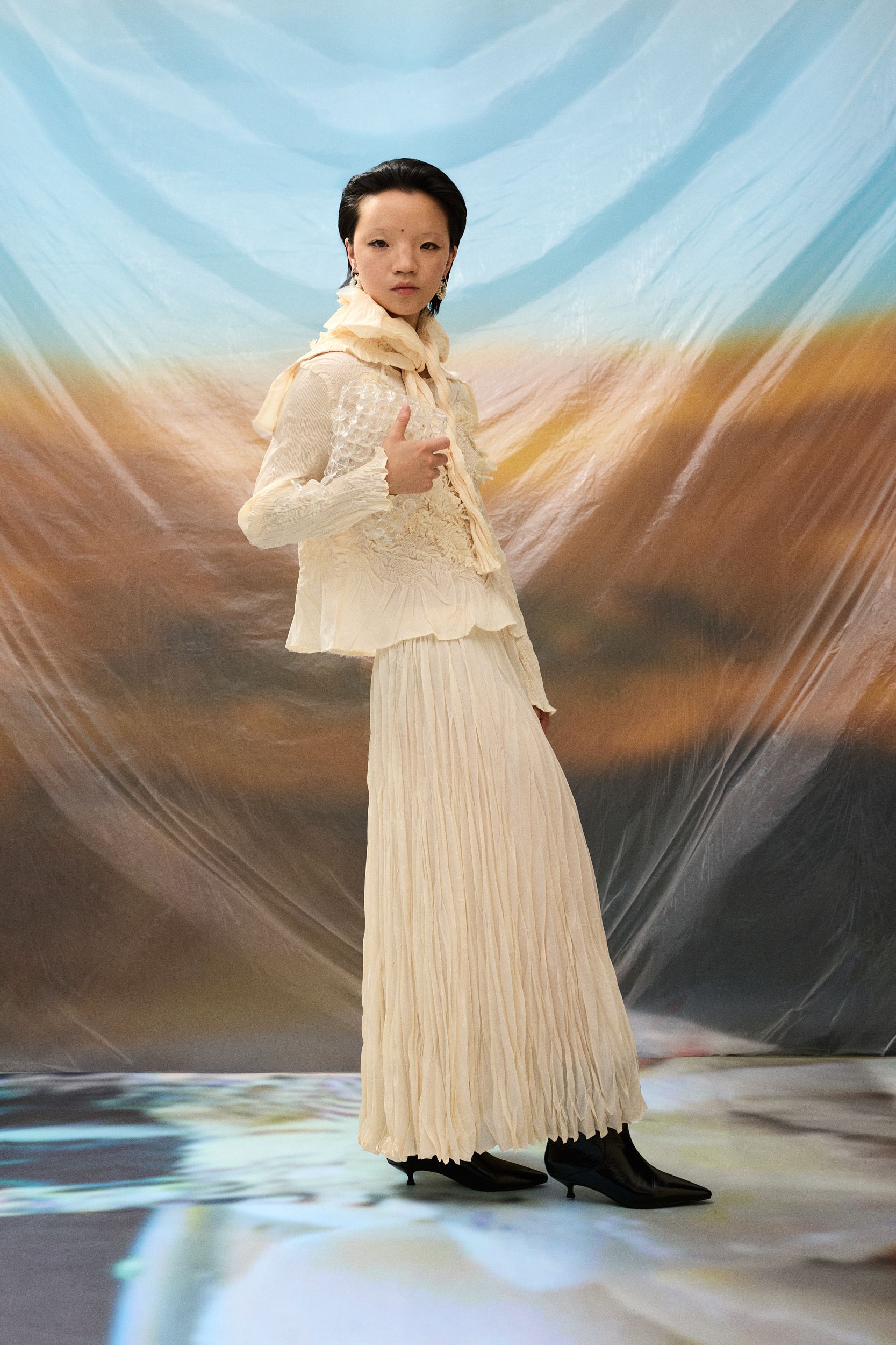 white pleated blouse and skirt with black boots