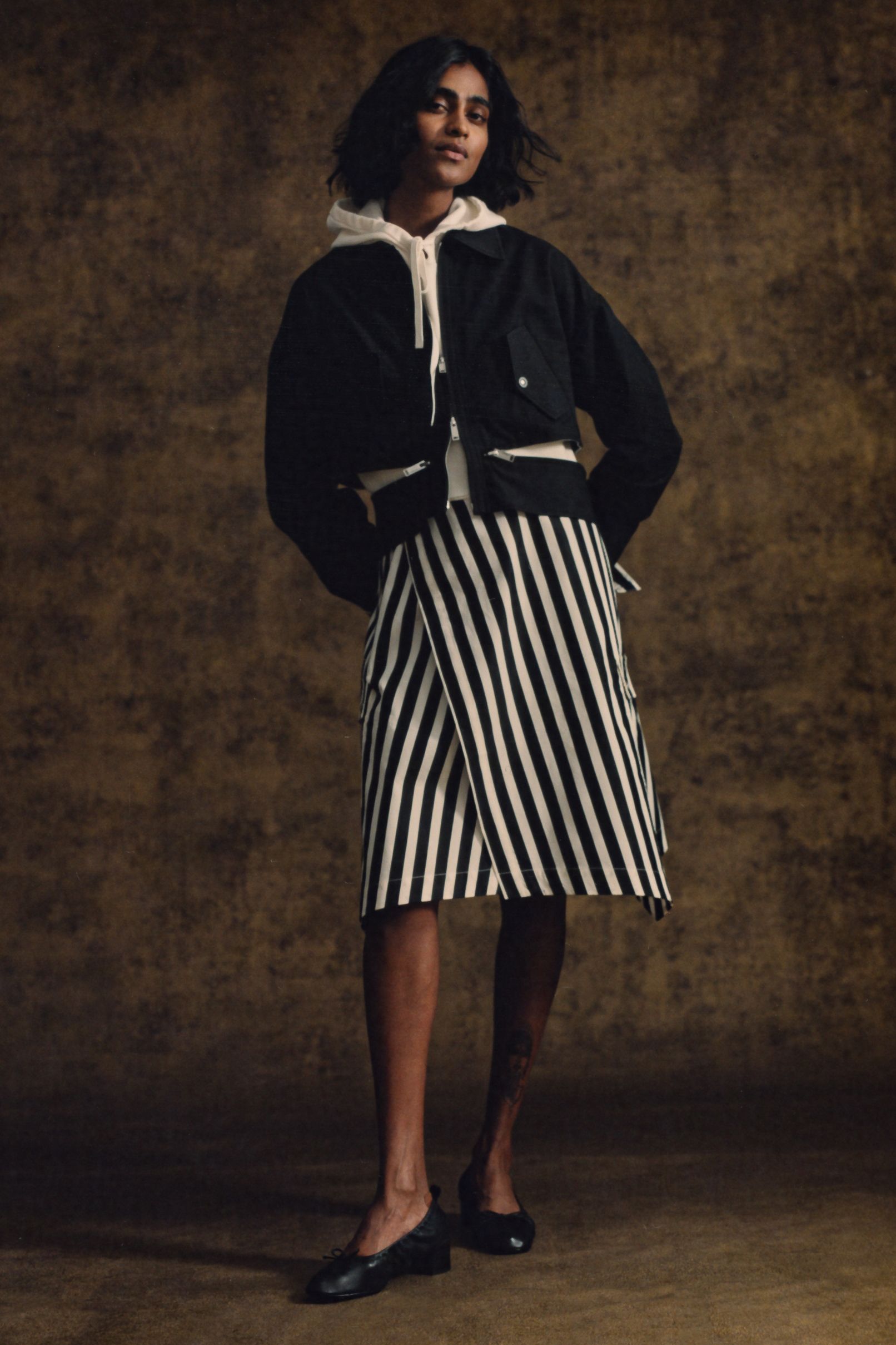 black jacket white hoodie striped skirt