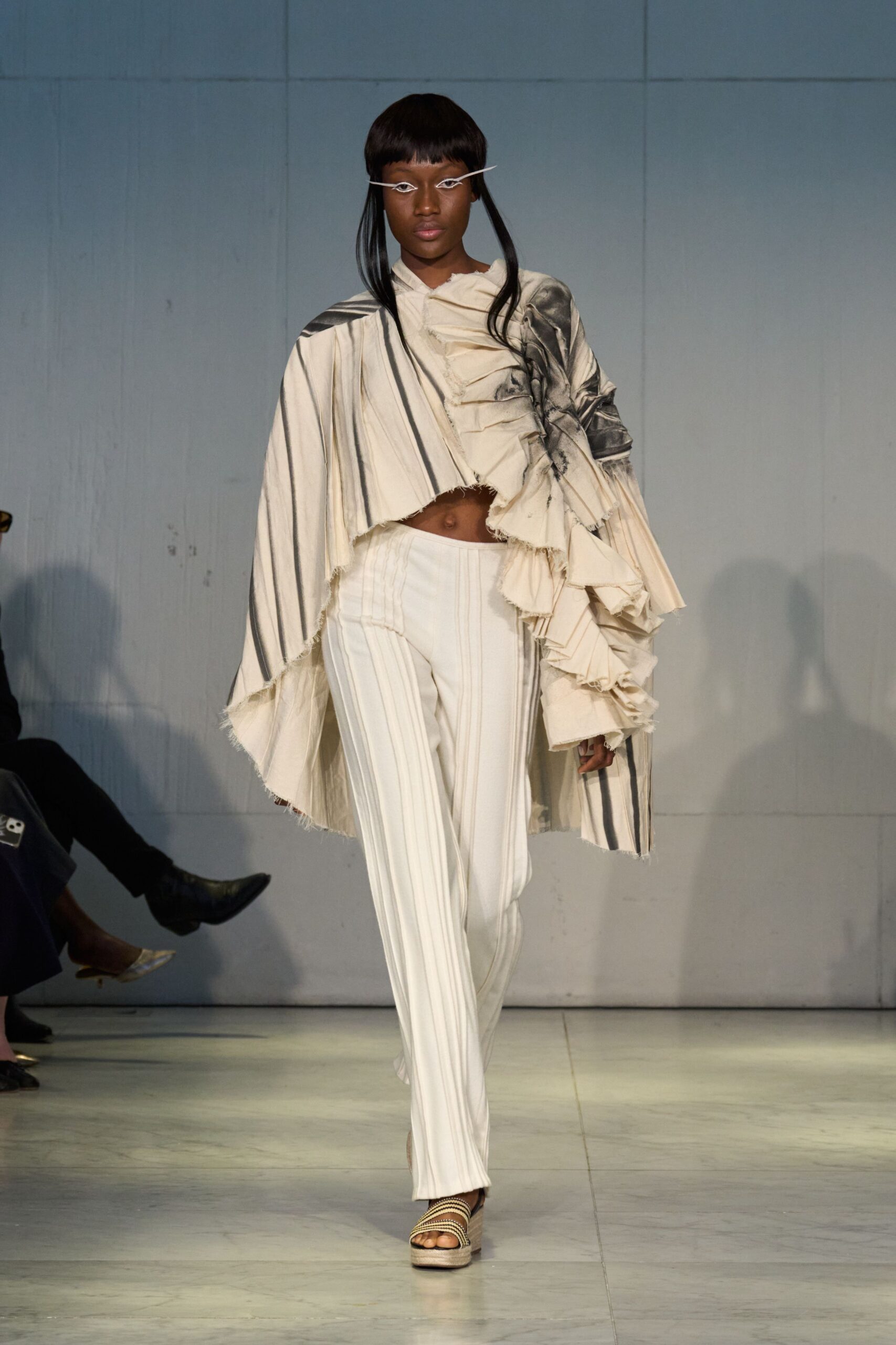 beige silk ruffled top with white striped pants