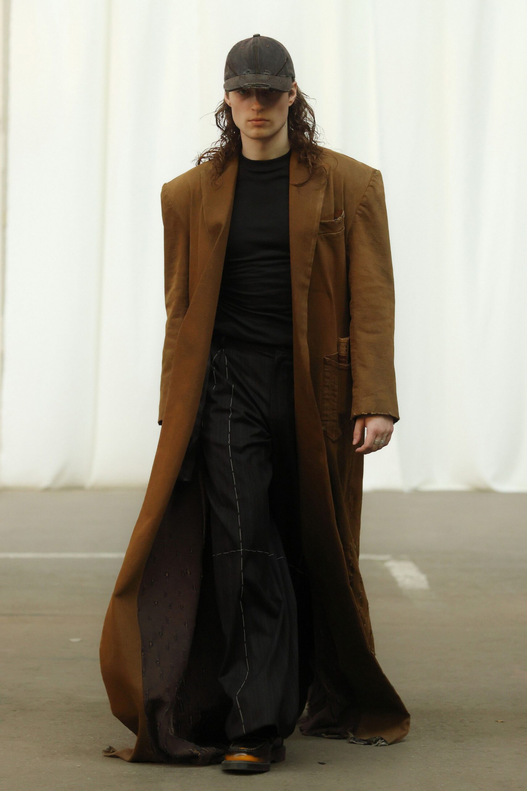 brown coat black top and pants