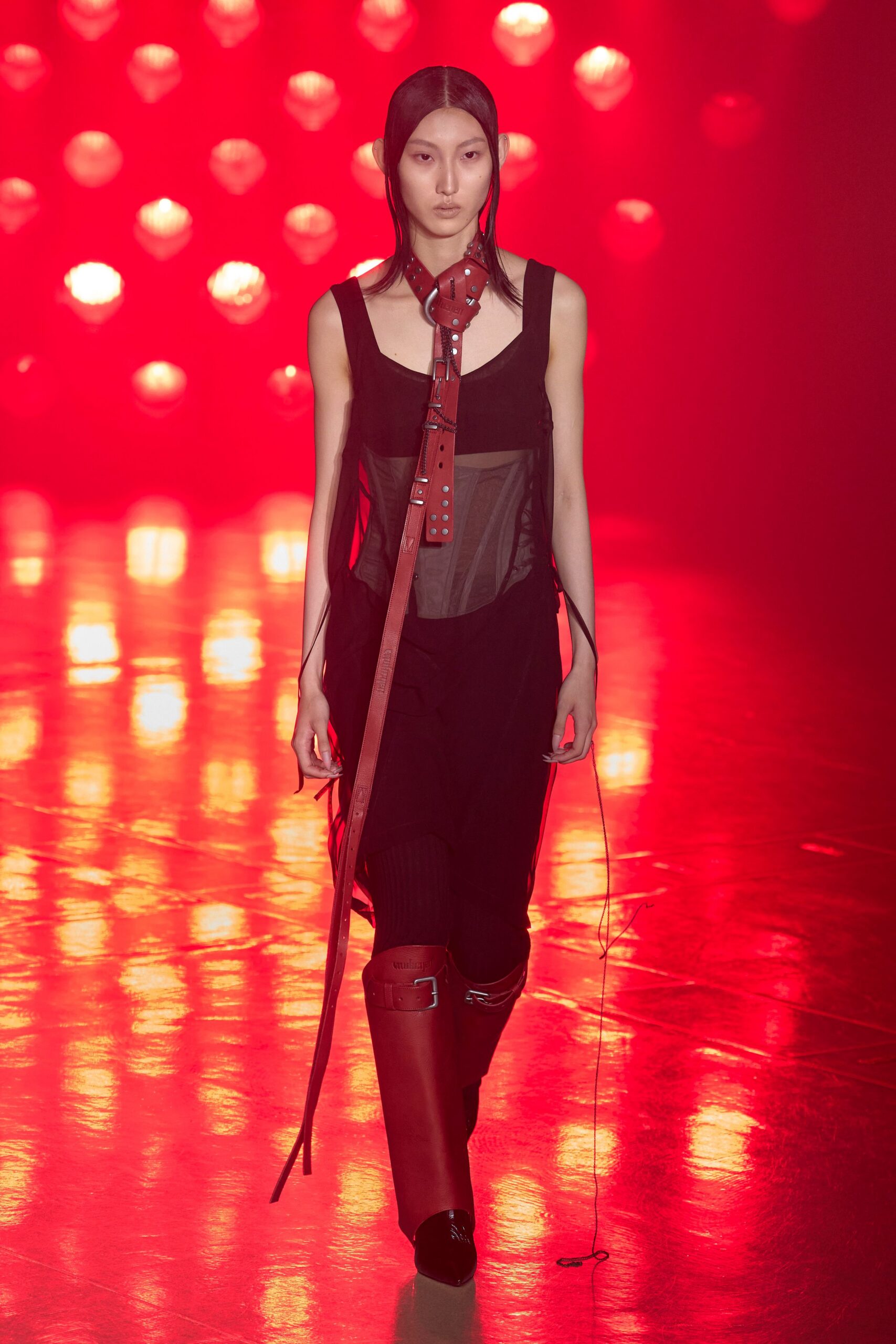 black fitted sleeveless dress with red boots