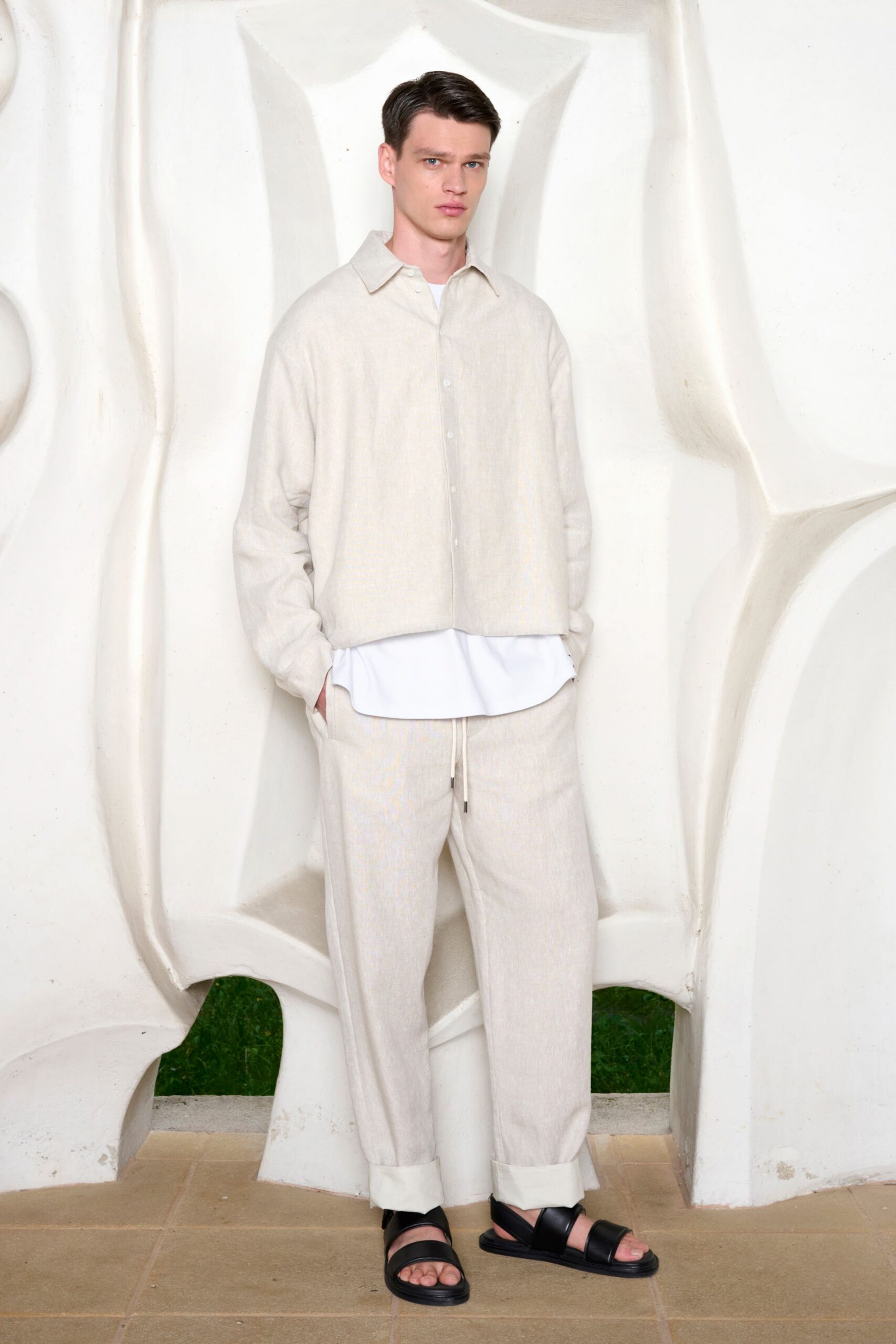 white relaxed shirt beige pants black sandals
