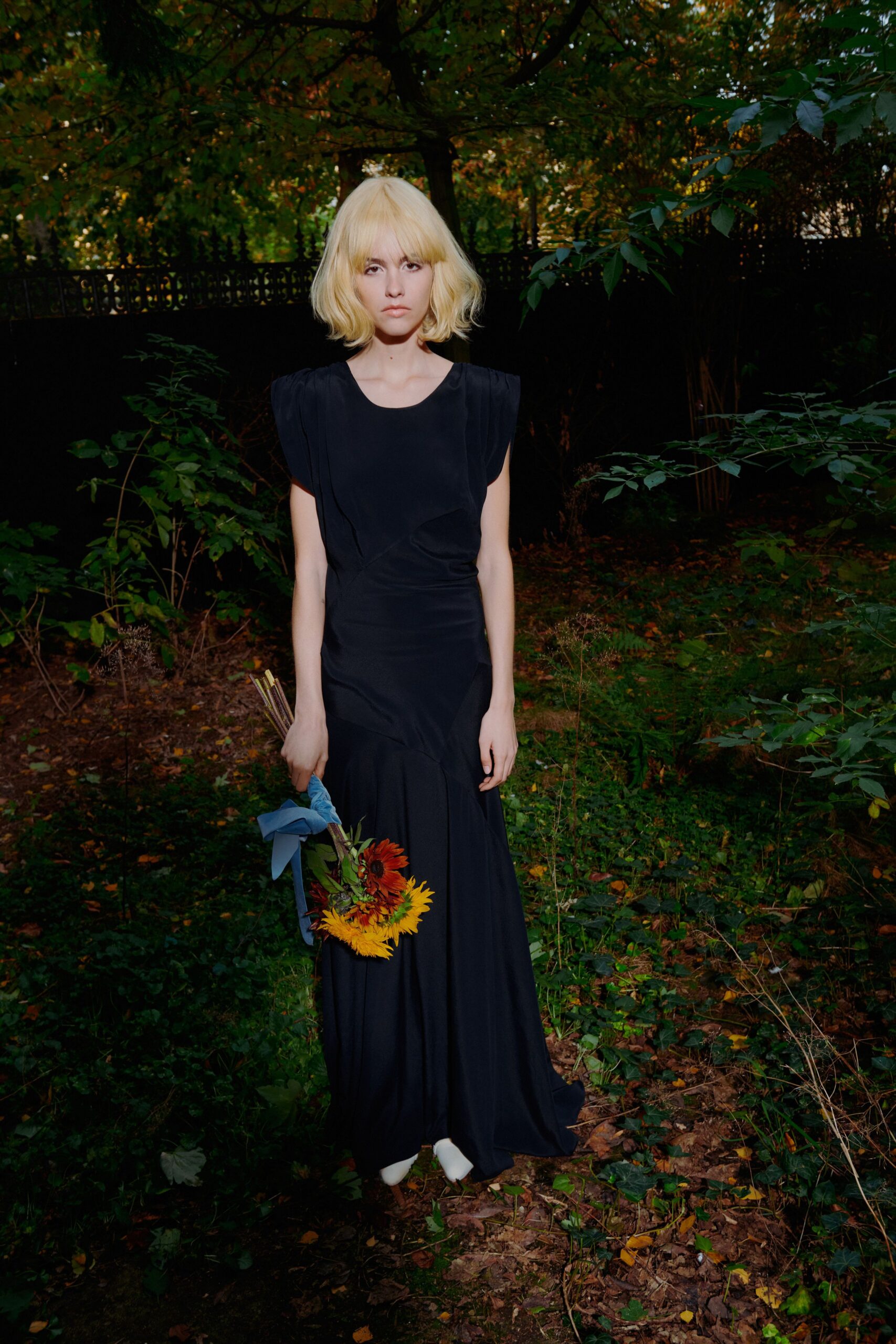 black silk sleeveless gown with white shoes