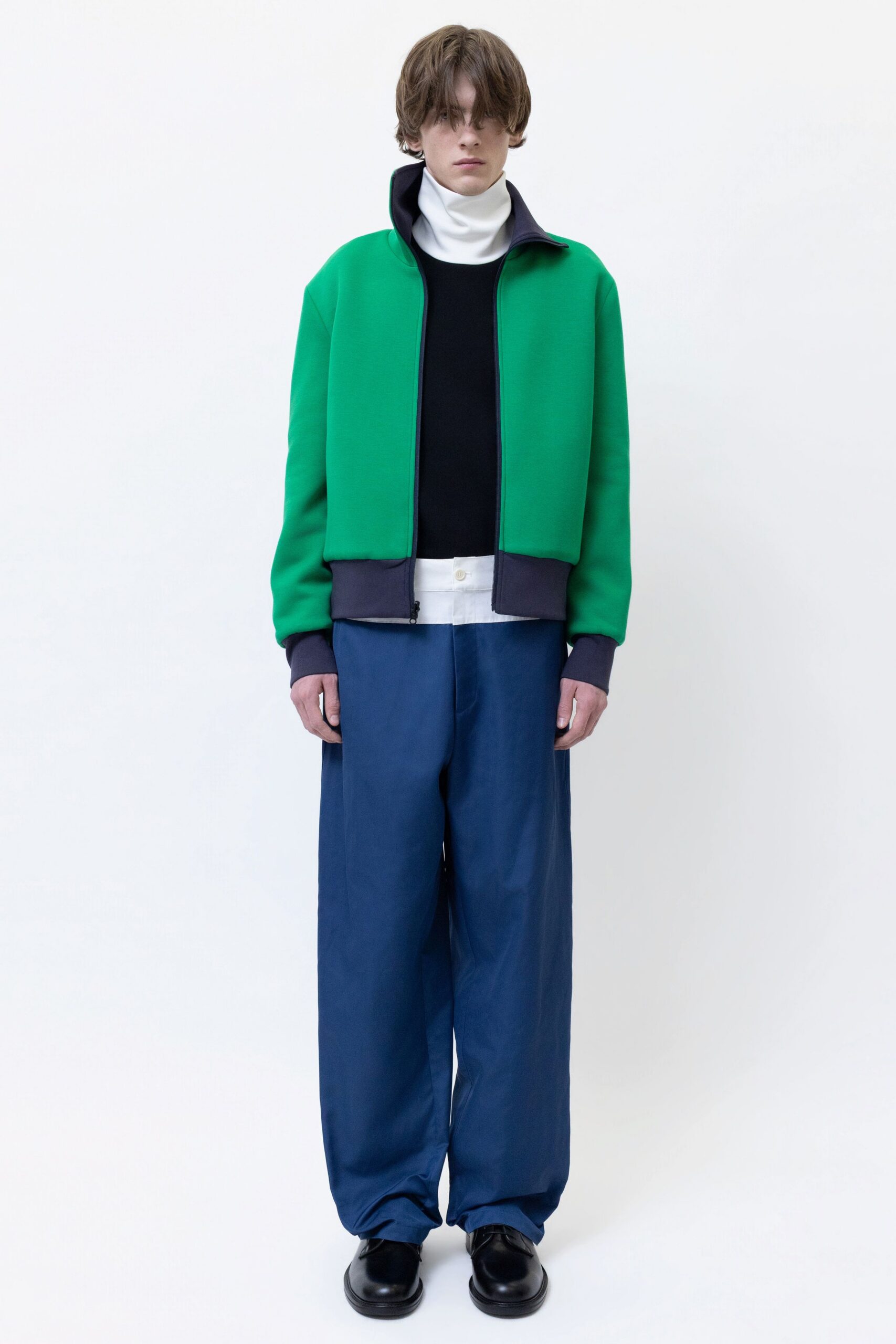 green jacket black top blue pants