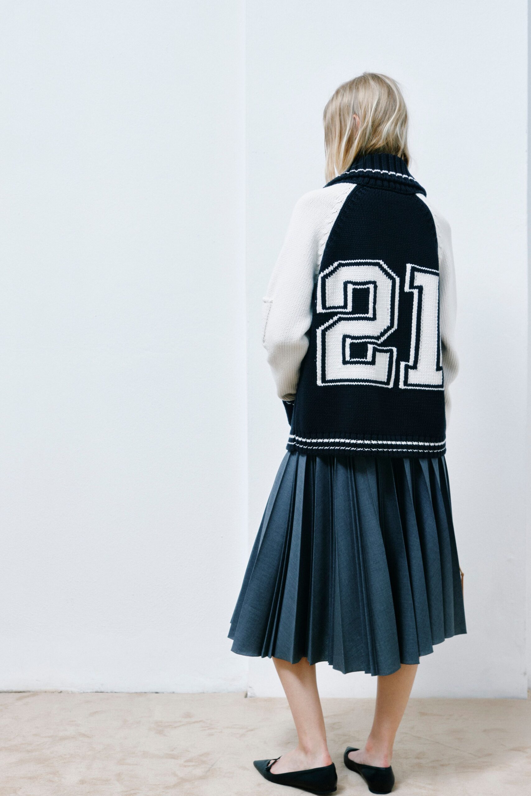 black and white relaxed sweater with pleated gray skirt