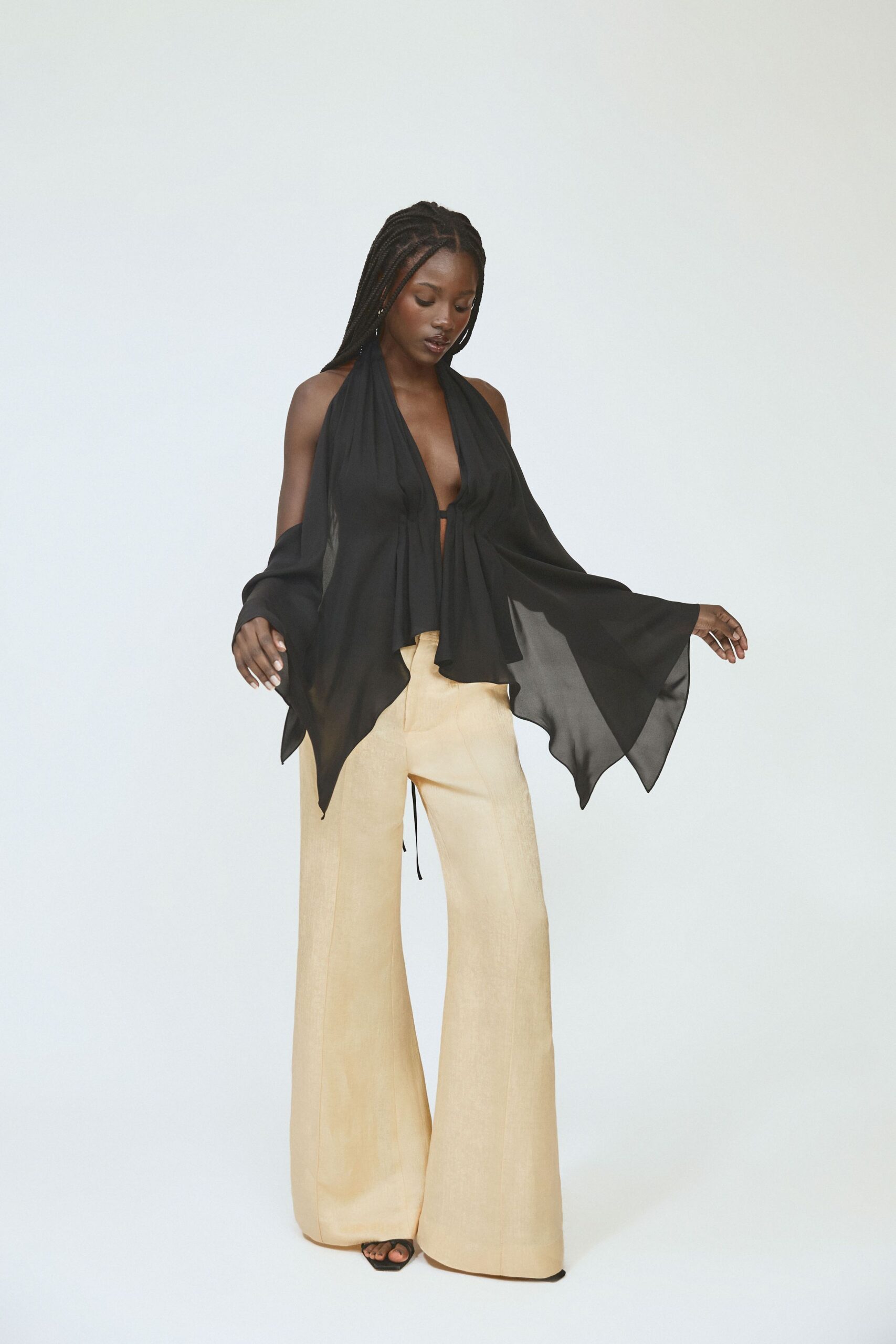 black chiffon top with beige wide-leg pants