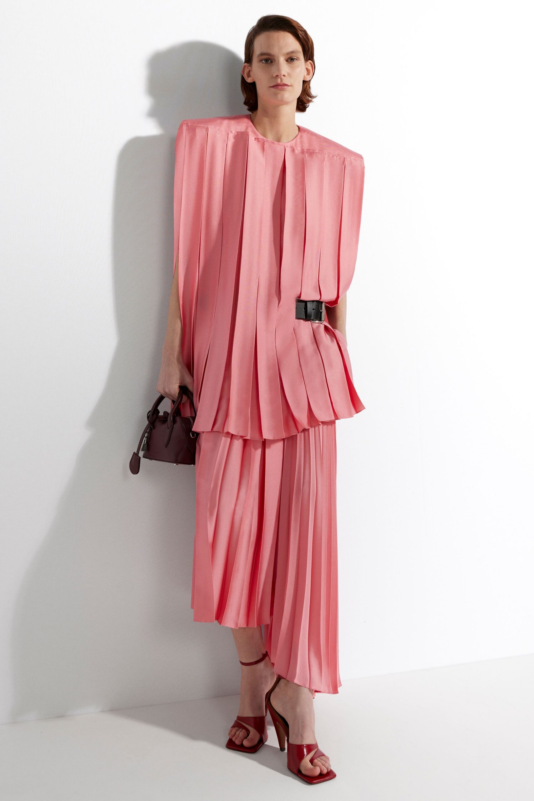pink pleated midi dress with red shoes