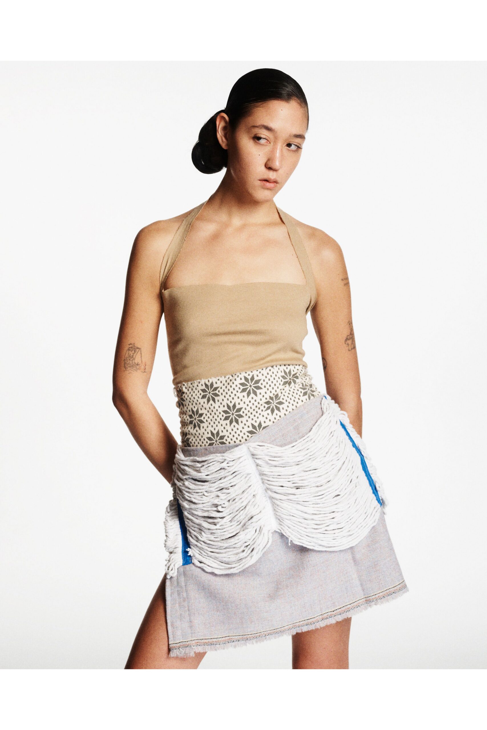 beige halter top and gray fringed skirt