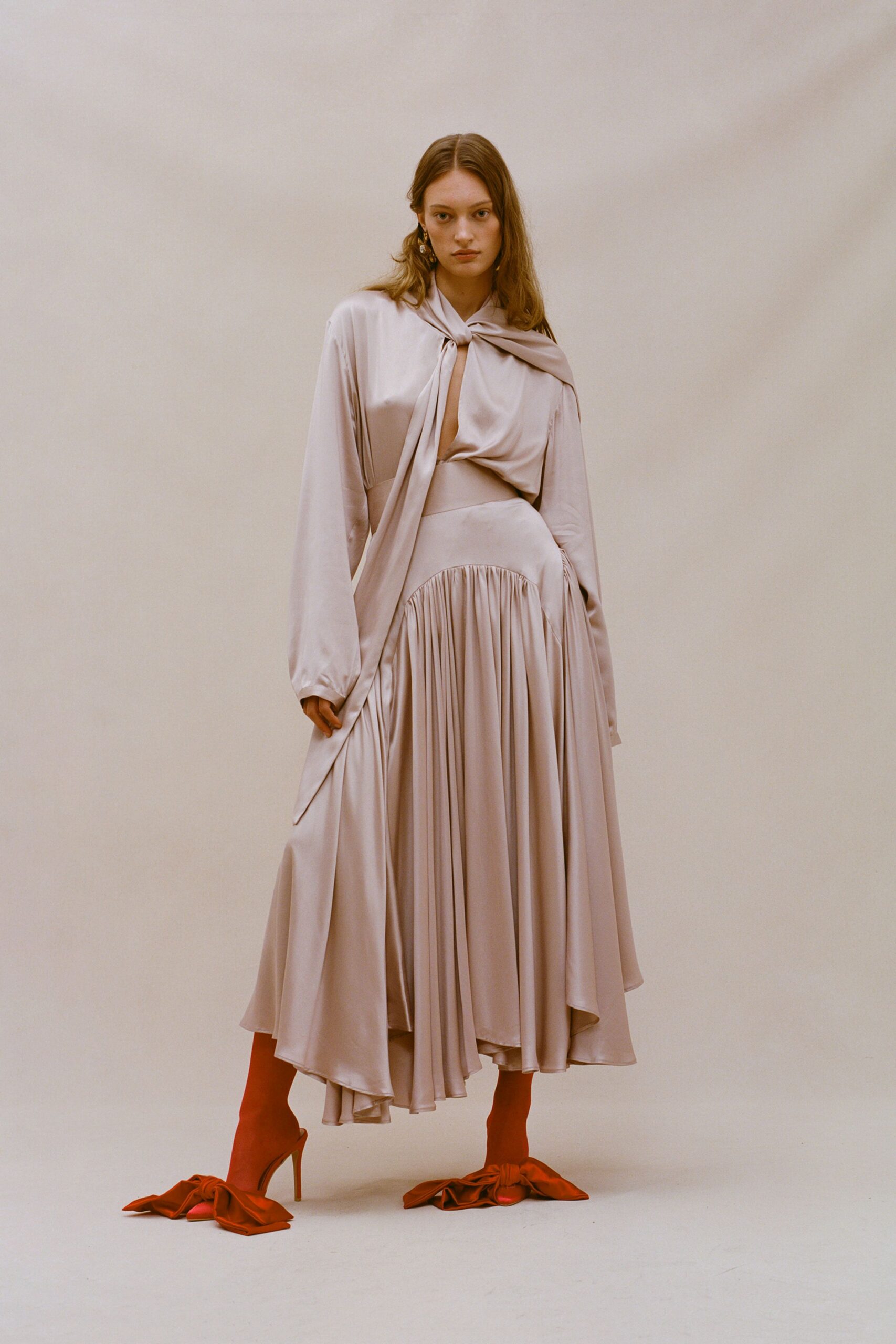 beige silk pleated midi dress with red shoes