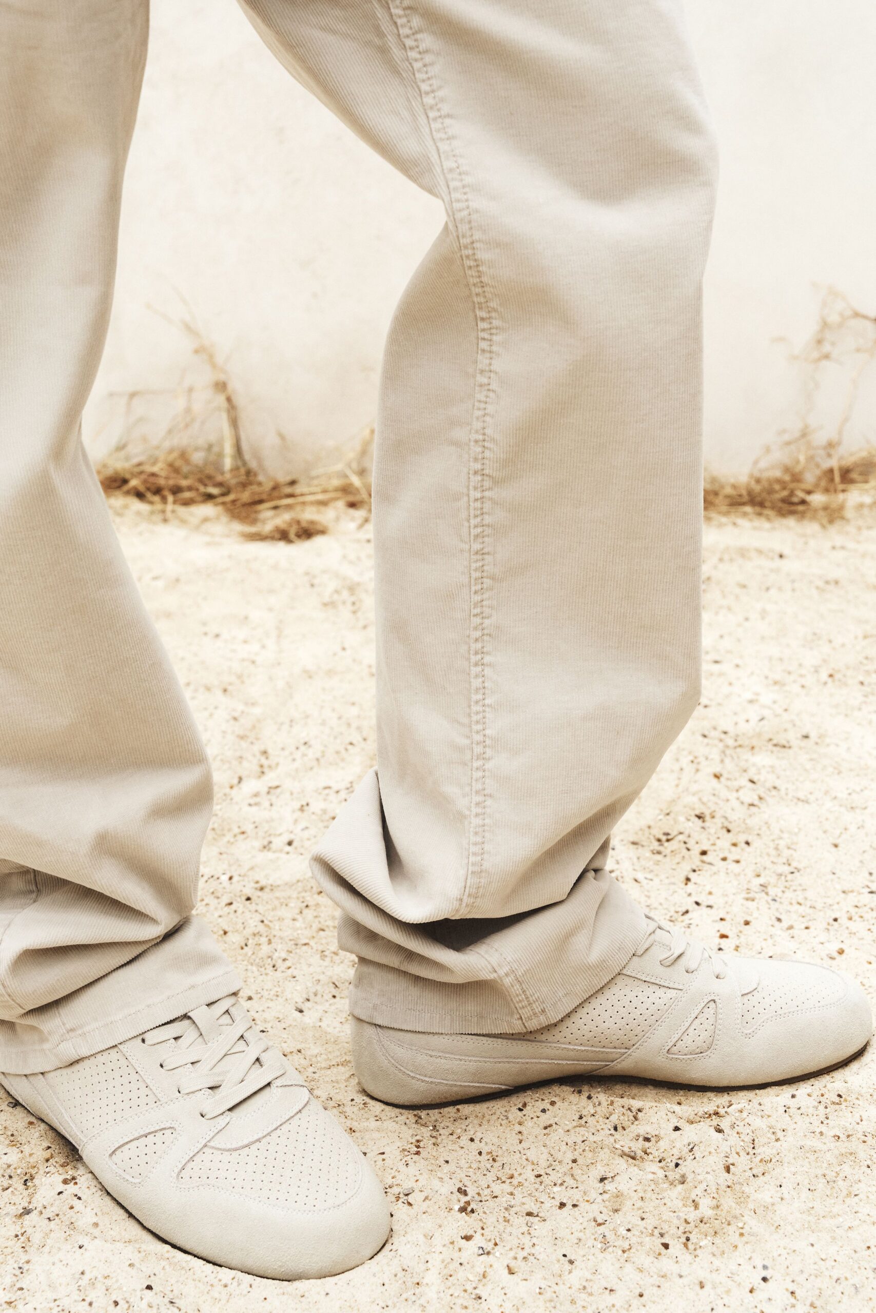 beige relaxed pants and gray sneakers